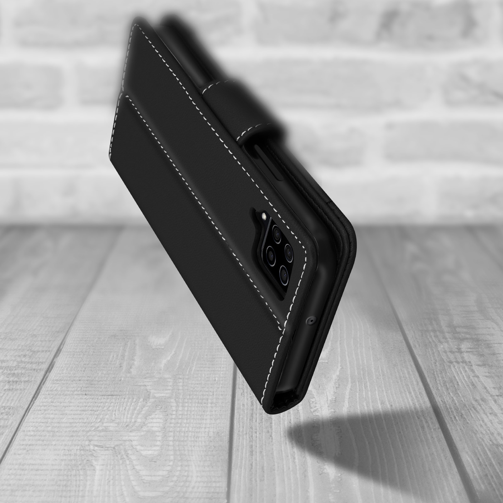 Un étui de téléphone noir avec des coutures blanches est présenté sur une surface en bois. L'étui est légèrement incliné.