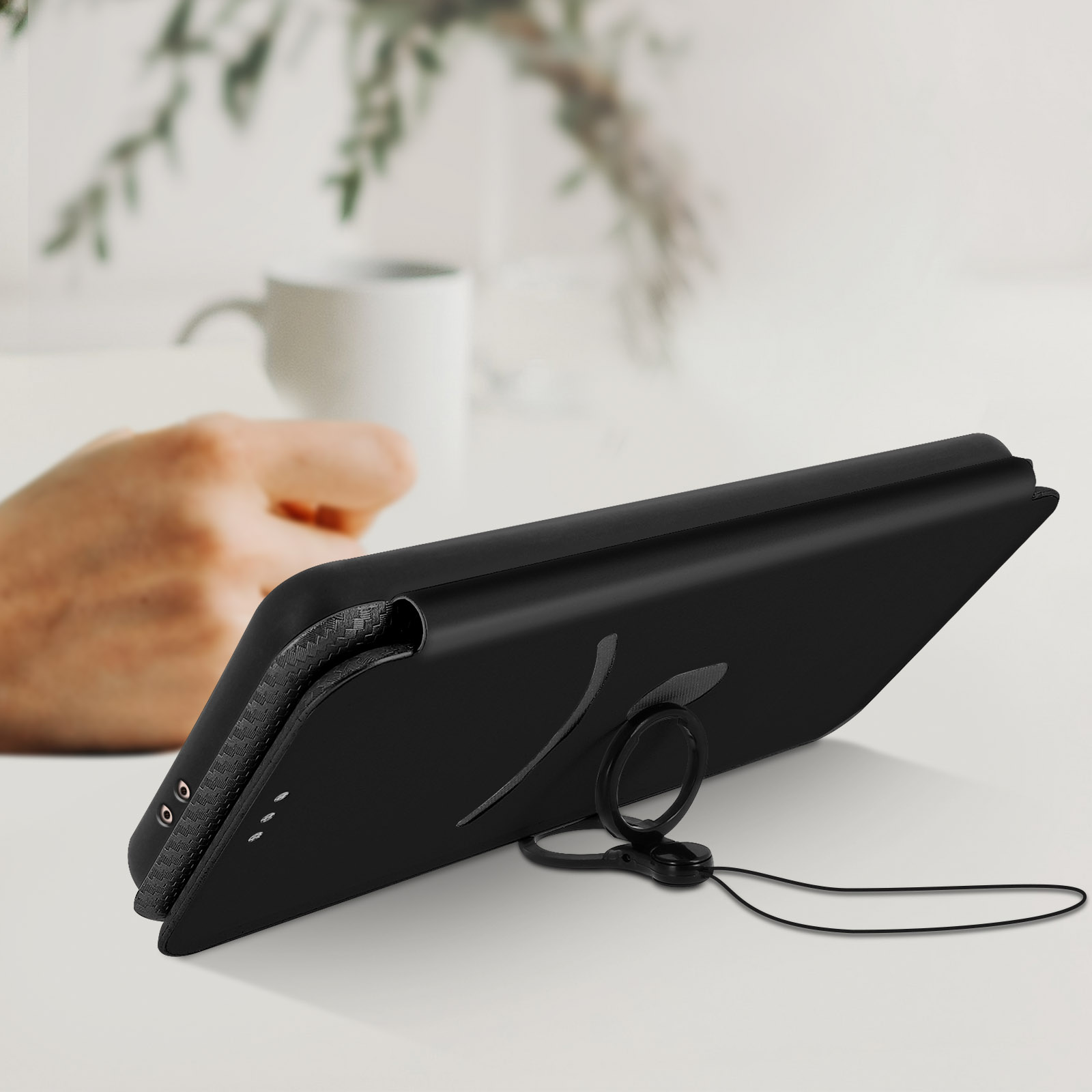 Custodia nera per telefono con anello di supporto. Il telefono è su una superficie bianca.