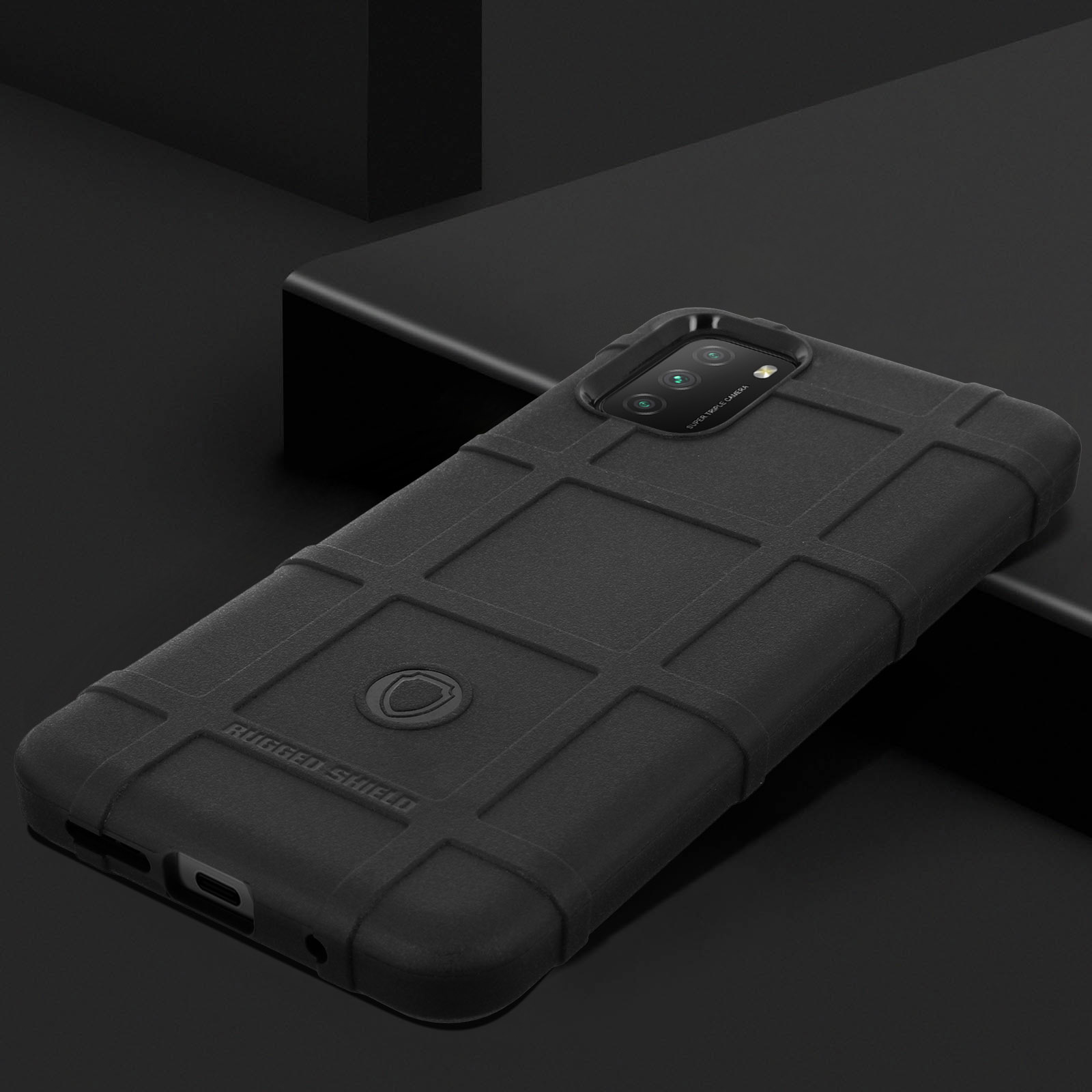 Custodia nera per telefono su superficie nera. Dice Rugged Shield. Fotocamera nell'angolo in alto.