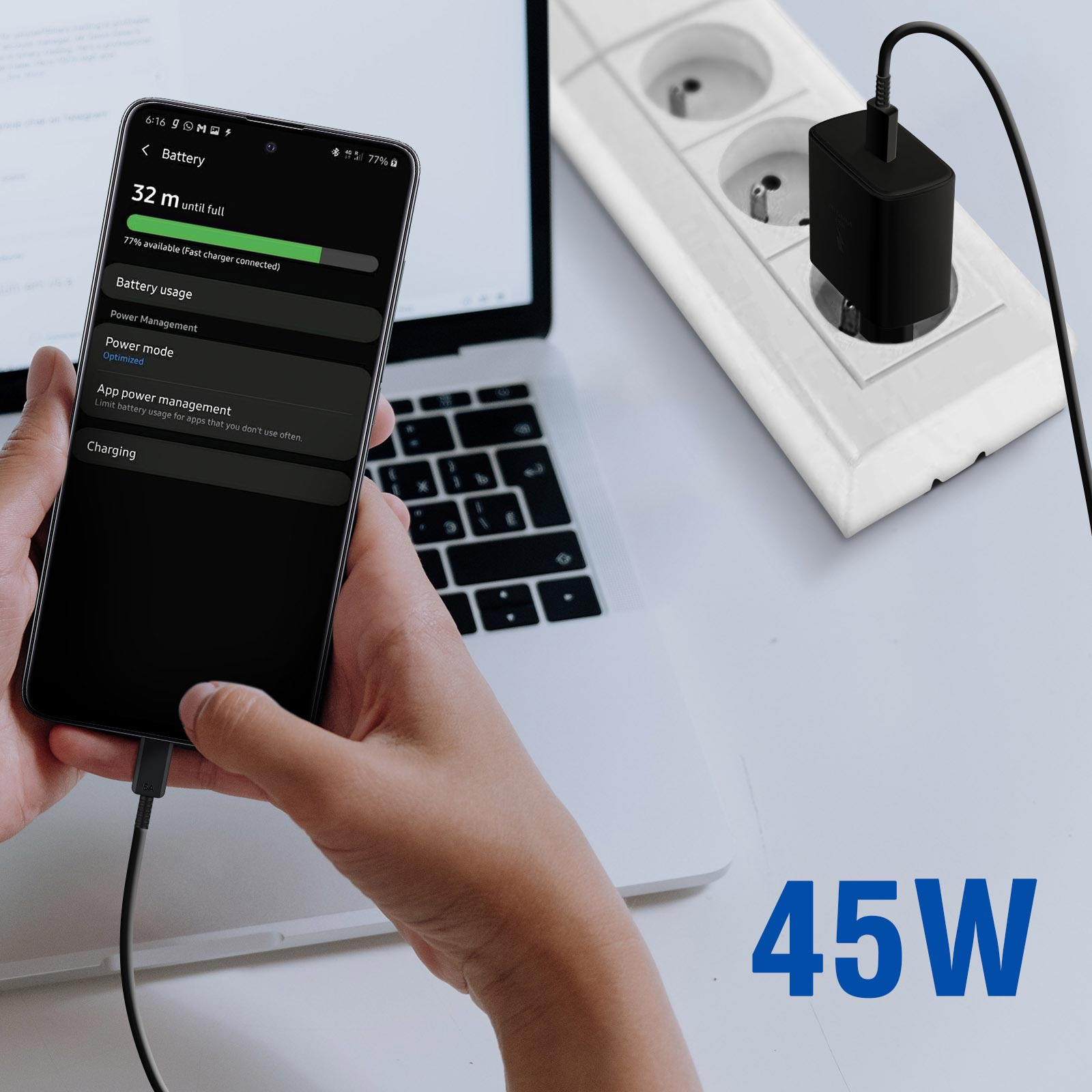 Une main tenant un téléphone en charge. Un chargeur est dans une prise. Le téléphone affiche les infos de batterie et de charge.