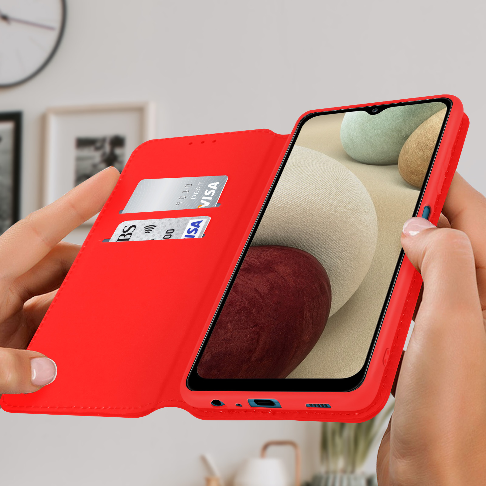 Un étui de téléphone rouge est ouvert. Un téléphone et des cartes de crédit sont visibles.