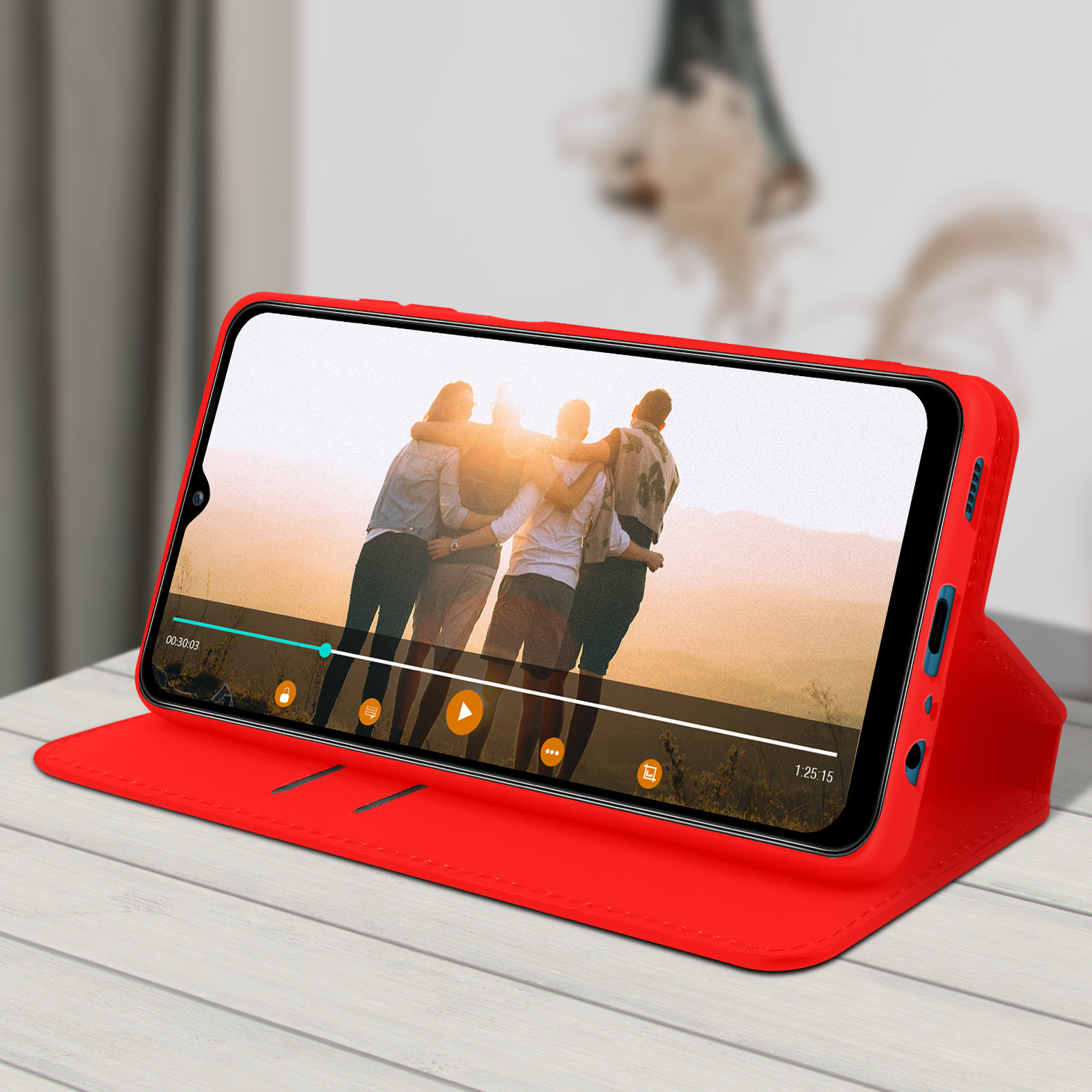 Telefoon in een rode hoes, met een video. De hoes ligt op een tafel.