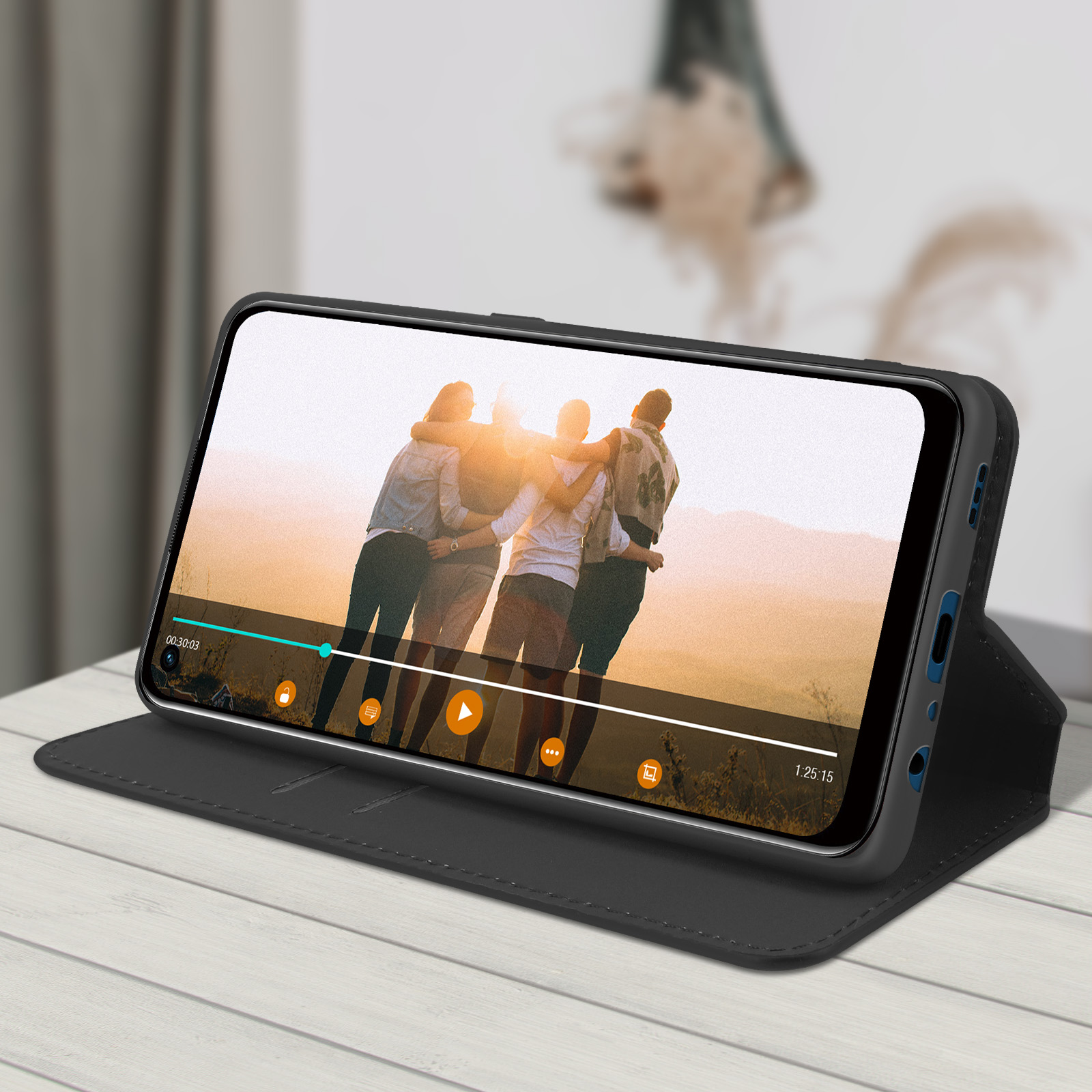 Telefoon met een video op het scherm. De telefoon zit in een zwarte hoes. De achtergrond is een kamer.