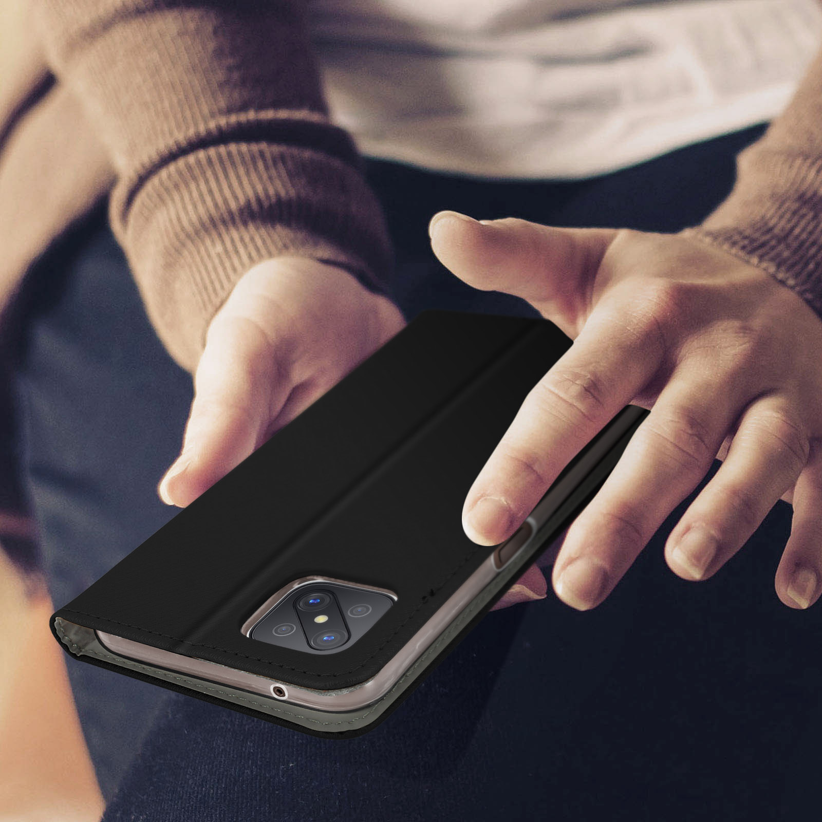 Le mani di una persona che tiene una custodia per telefono nera.
