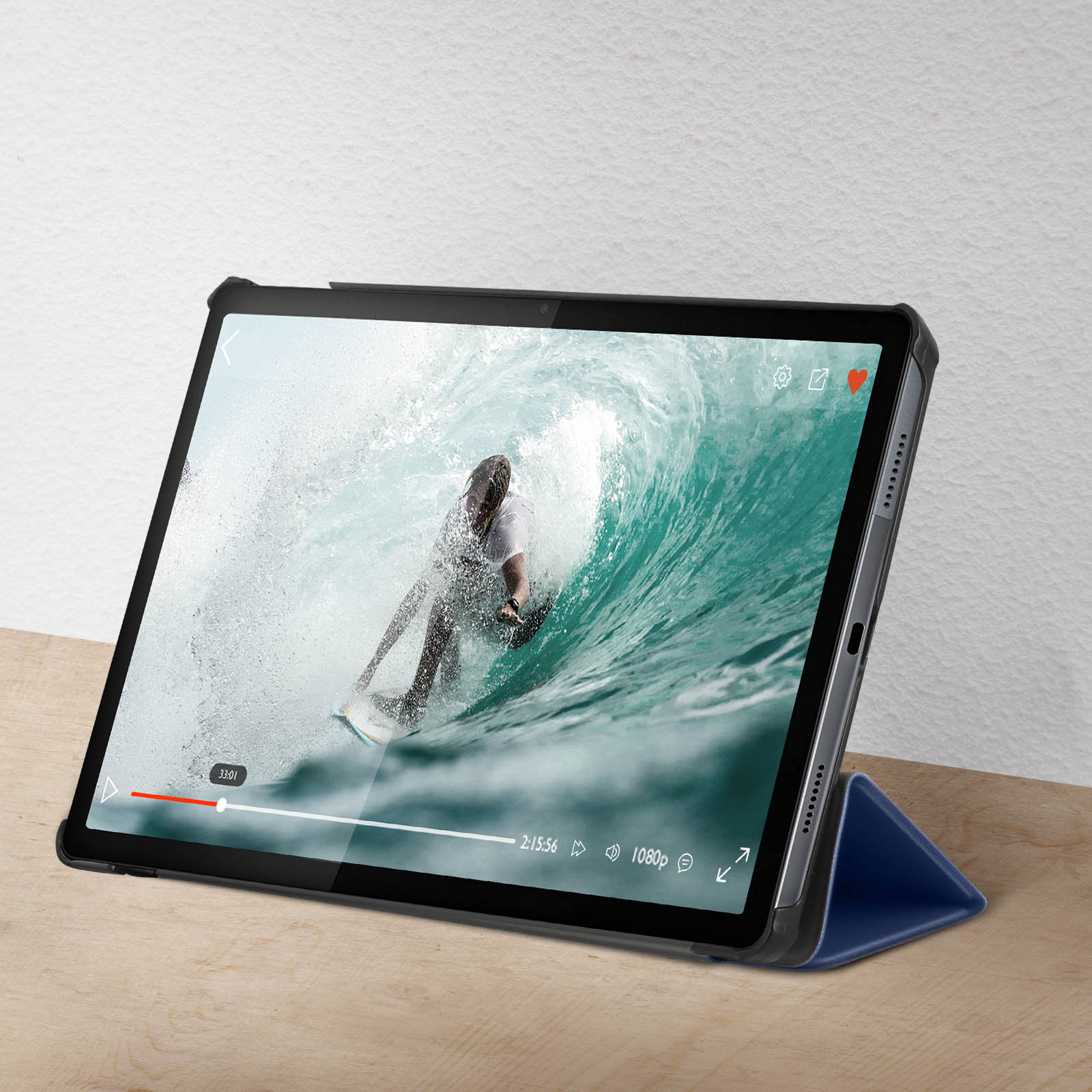 Tablet che mostra un surfista su un'onda. Custodia blu sostiene il tablet.