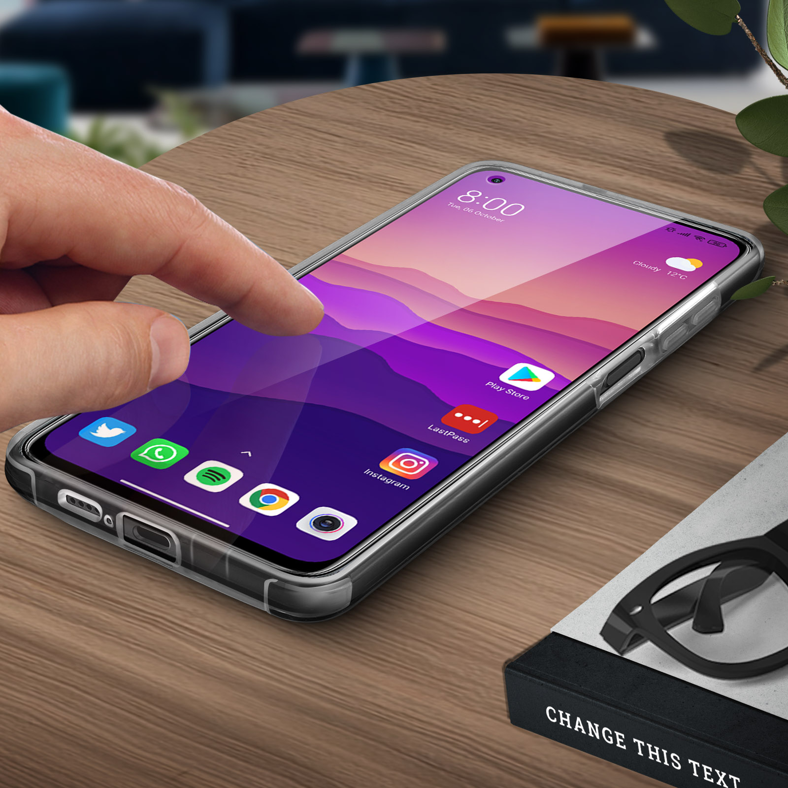 Dito che tocca lo schermo del telefono con icone delle app. Tavolo di legno. Testo: Change This Text.
