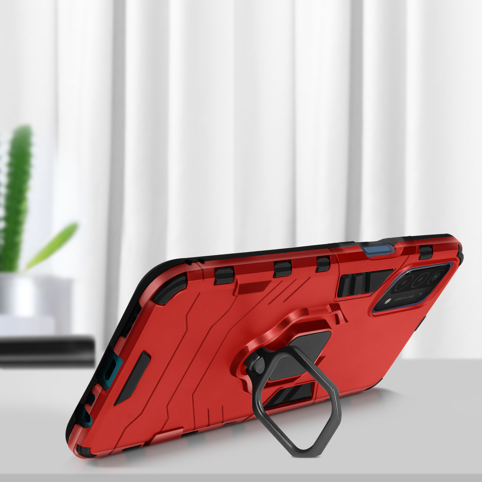 Une coque de téléphone rouge avec un support annulaire. Le téléphone est sur une surface blanche. La caméra est visible.