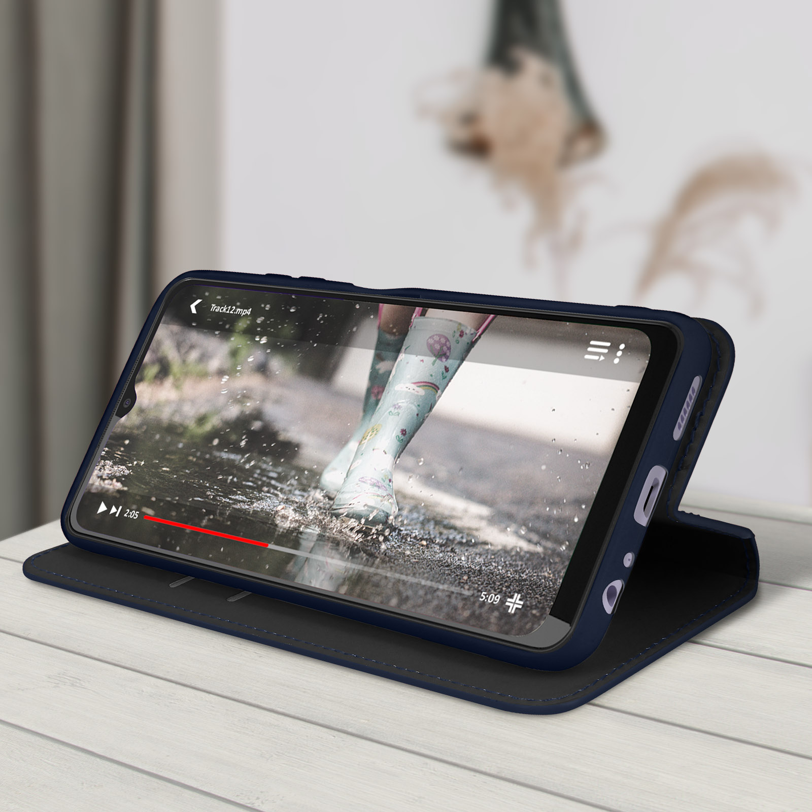 Téléphone dans un étui affichant une vidéo. Le téléphone repose sur une surface en bois.