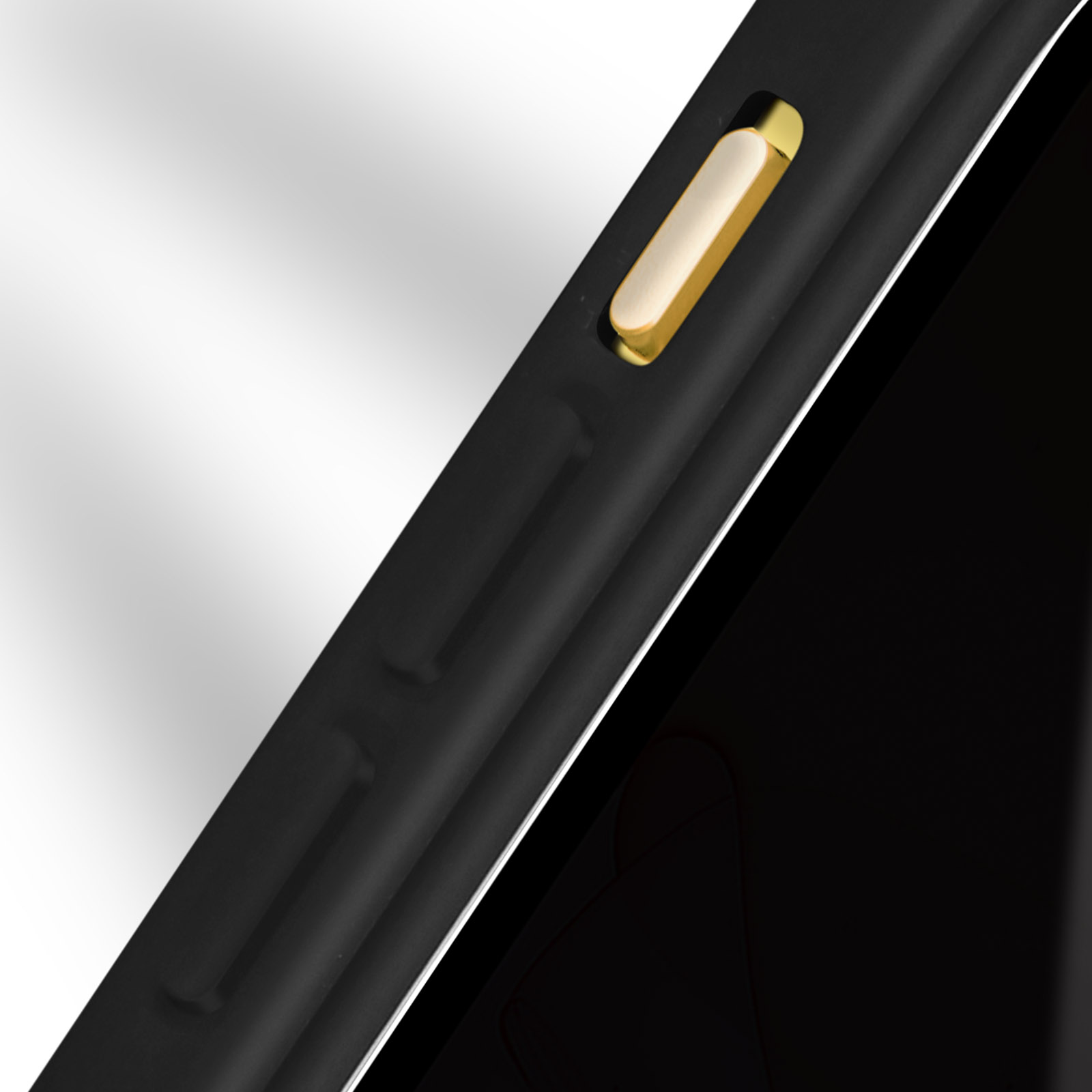 Primo piano di un telefono nero con un pulsante dorato. I bordi sono anch'essi neri.