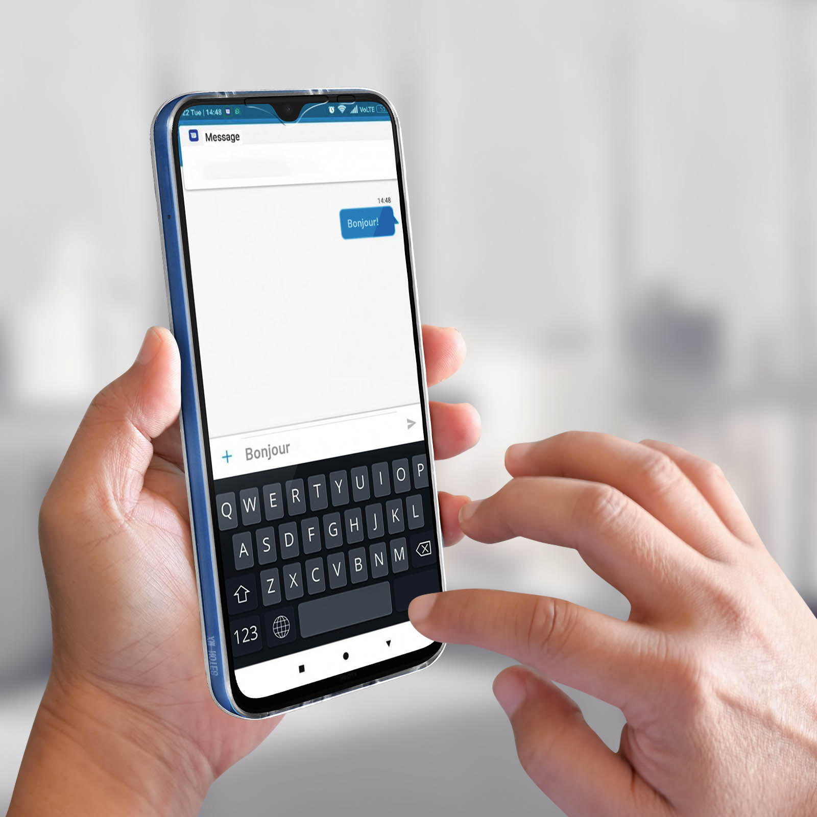 Hand die telefoon vasthoudt met Frans bericht 'Bonjour' op toetsenbord.