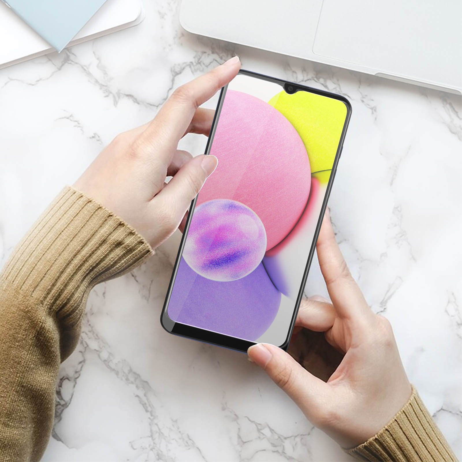 Mani che tengono un telefono, mostrando un design astratto rosa, giallo e viola sullo schermo.