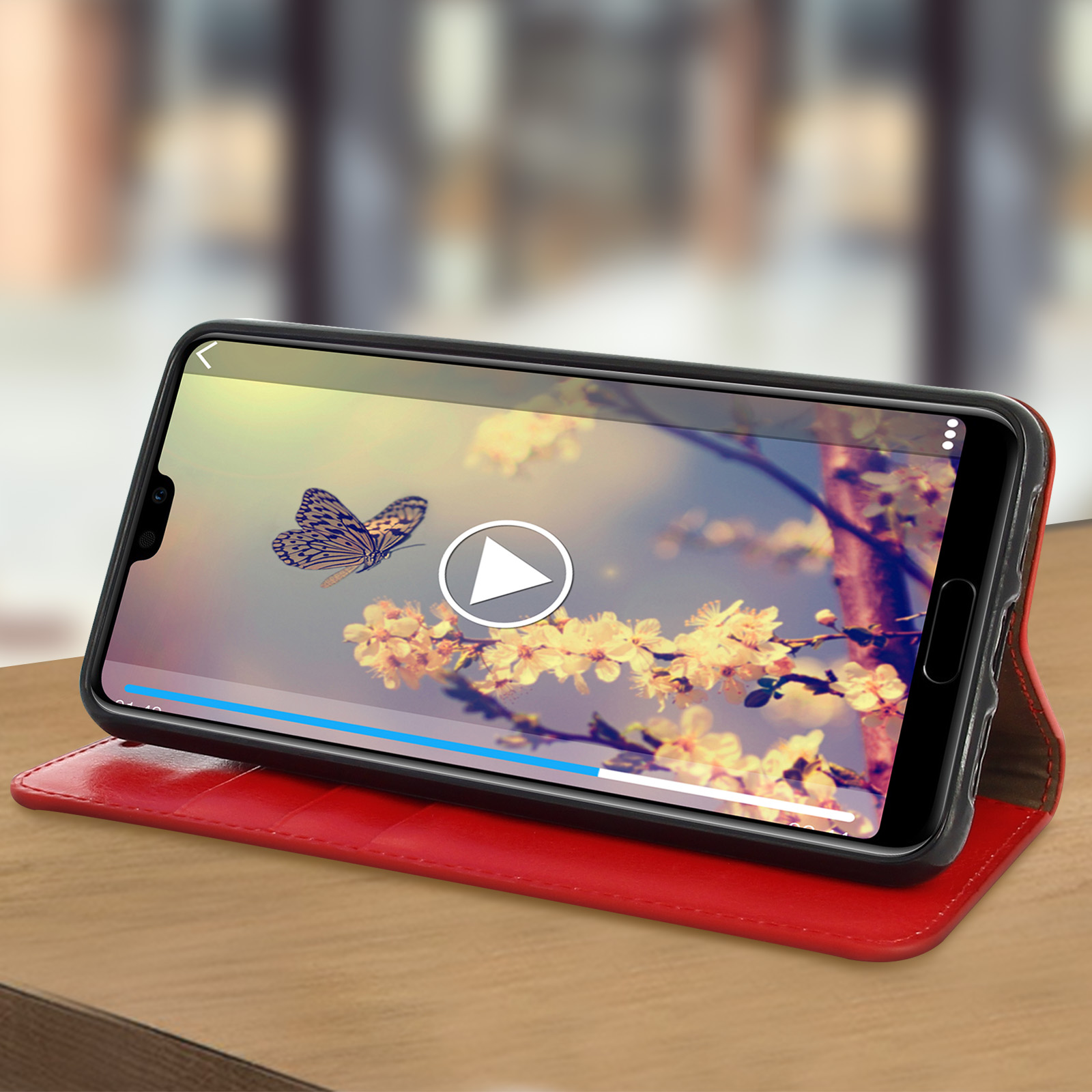 Un telefono mostra un video di una farfalla e fiori, posizionato su un tavolo.