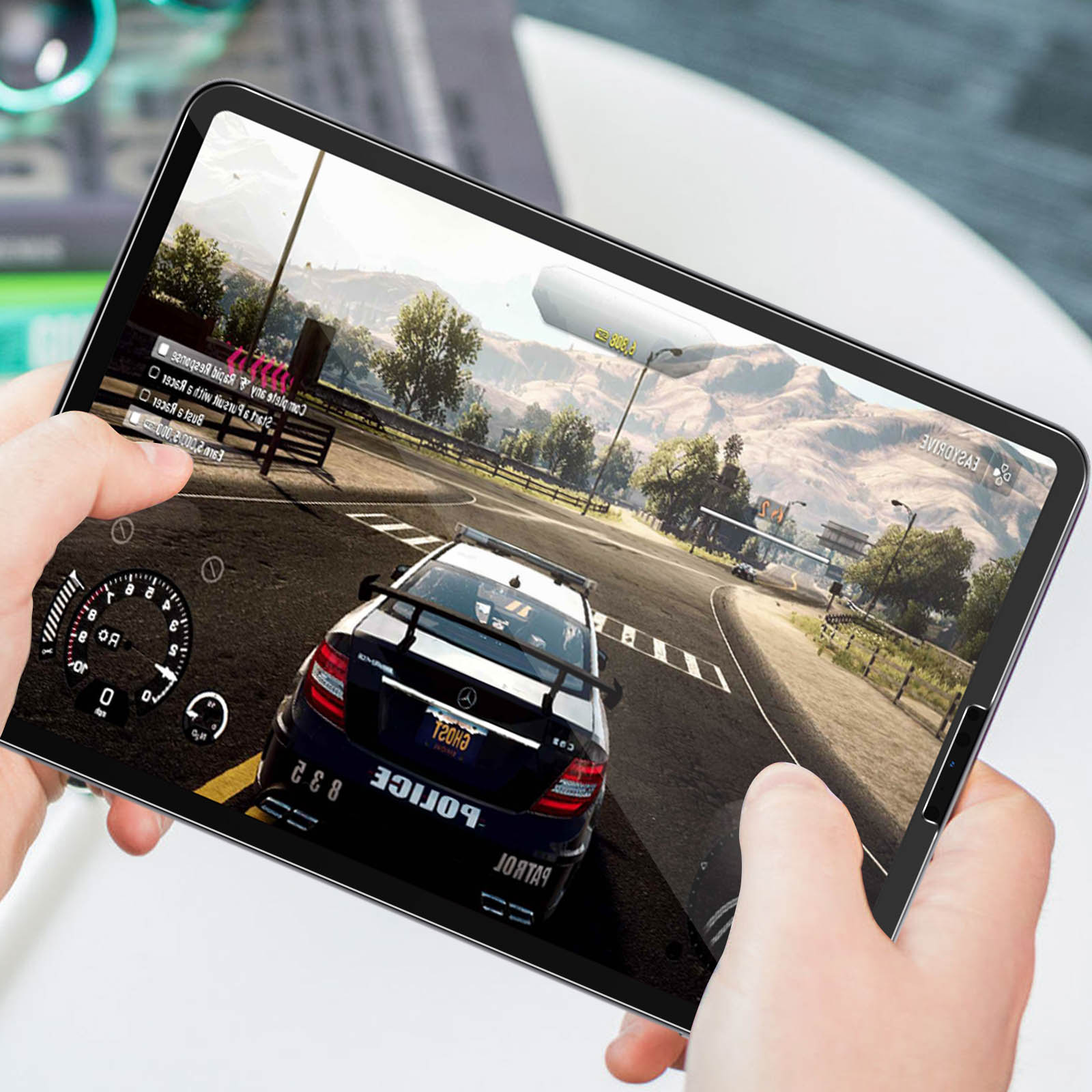 Tablet che mostra un gioco di corse. Mani che tengono il tablet. Sfondo bianco.