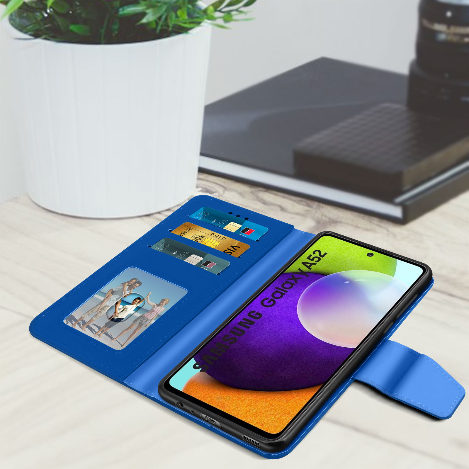 Una custodia blu per telefono aperta, che mostra carte di credito e una foto di famiglia. Il telefono mostra il Galaxy A52.