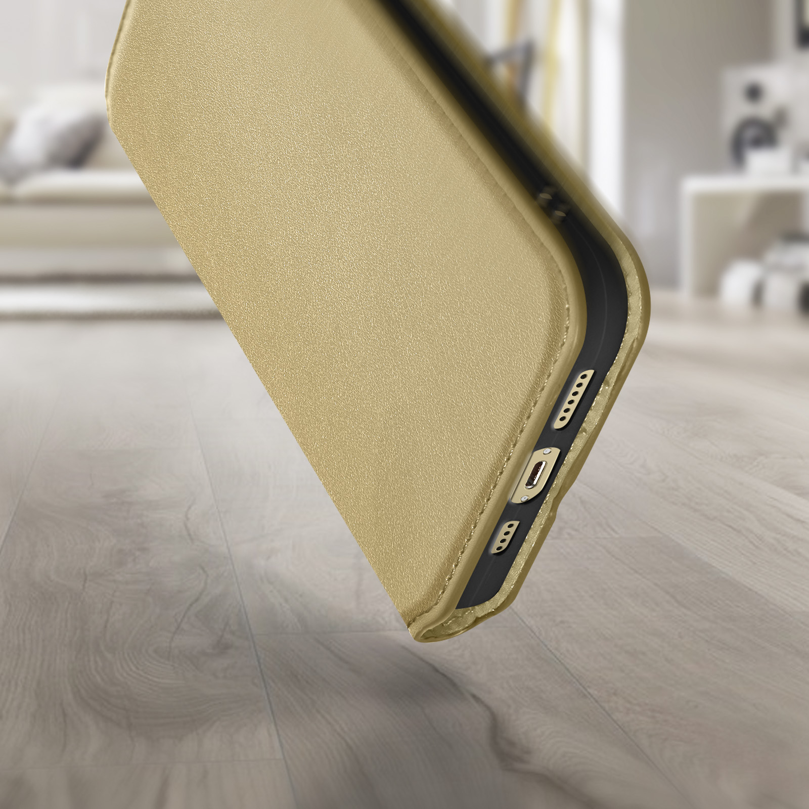 Coque de téléphone dorée sur surface en bois. Arrière-plan flou avec intérieur.
