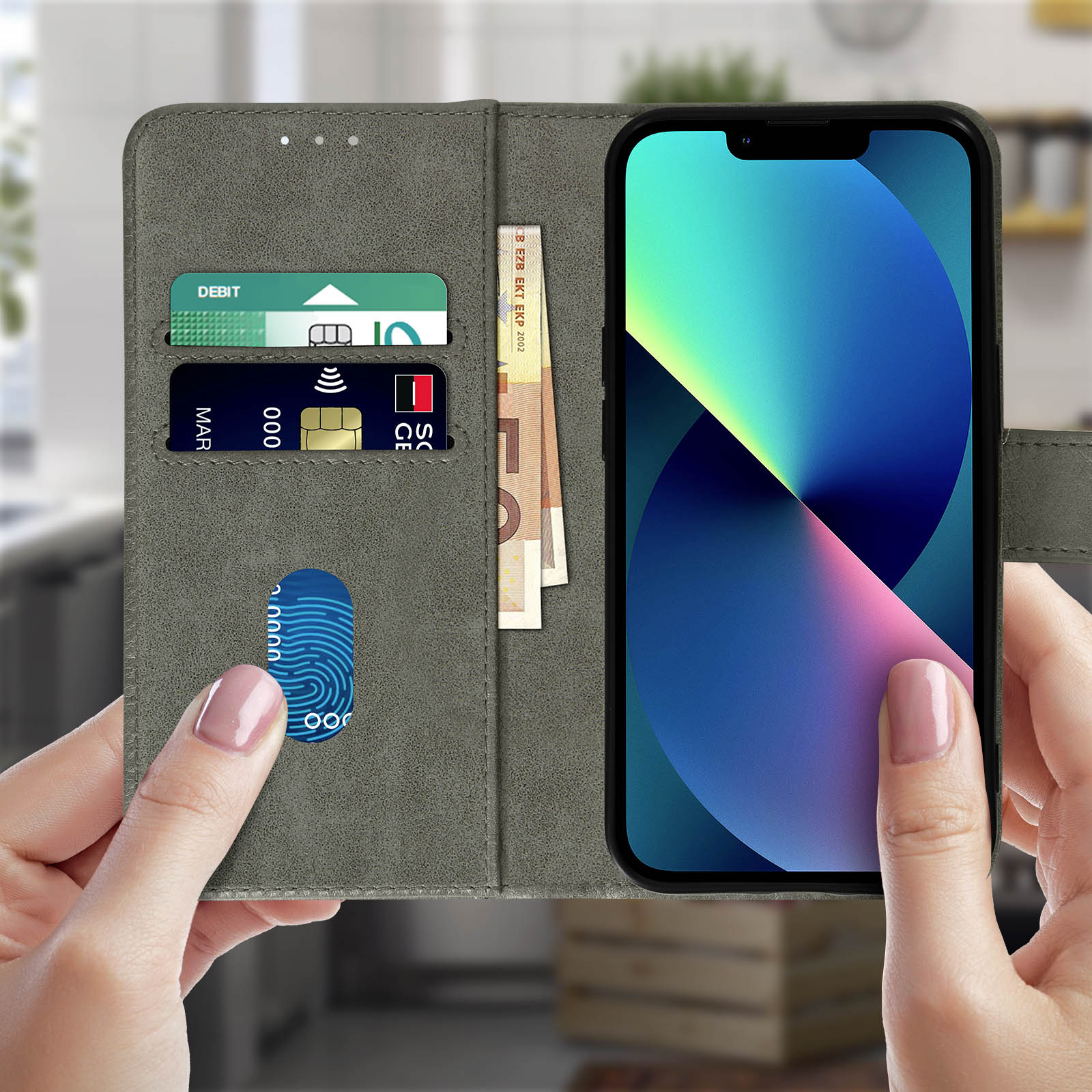 Mano che tiene aperta una custodia grigia con telefono dentro. Carte e denaro nella custodia.