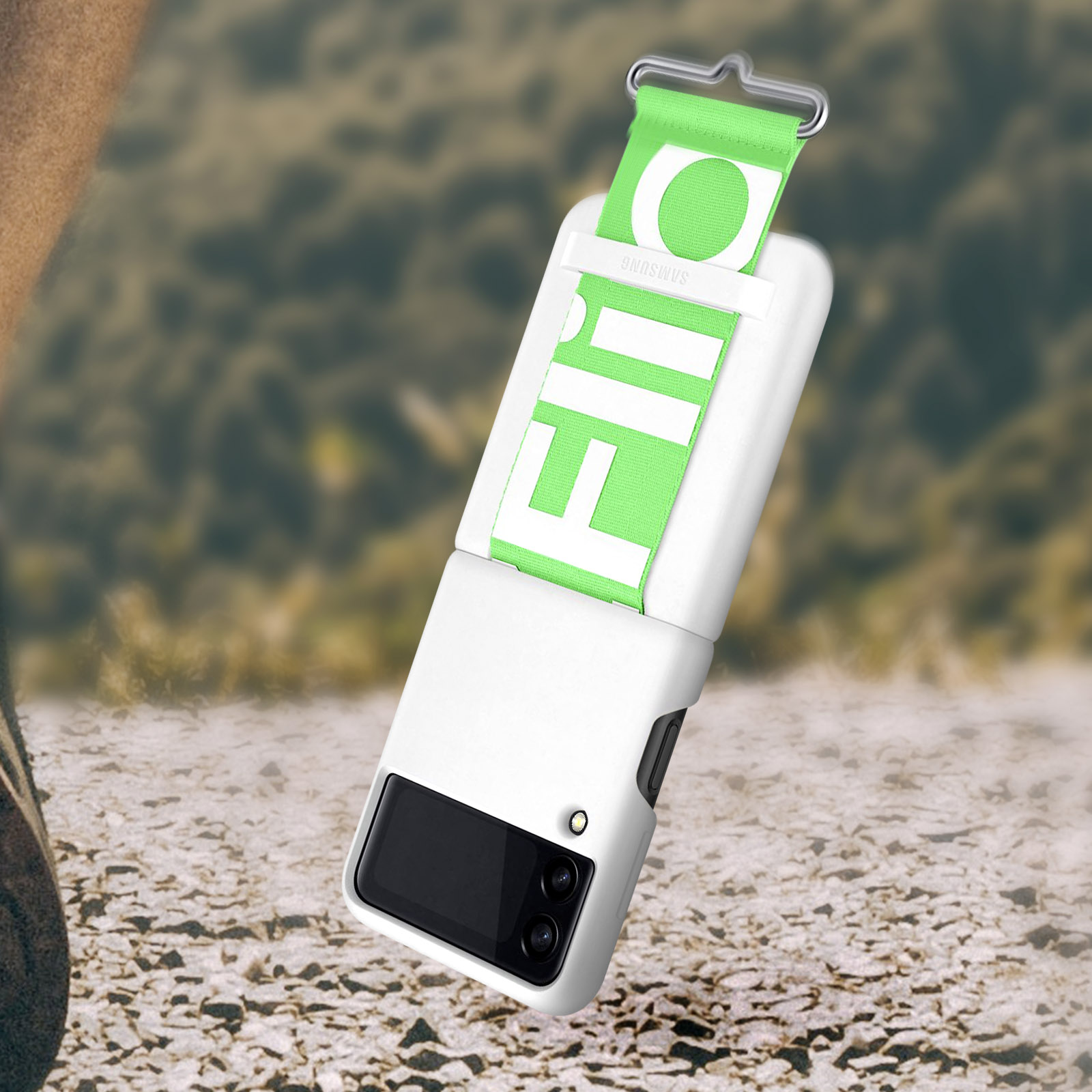 Białe etui na telefon z zielonym paskiem. Etui na teksturowanym podłożu.