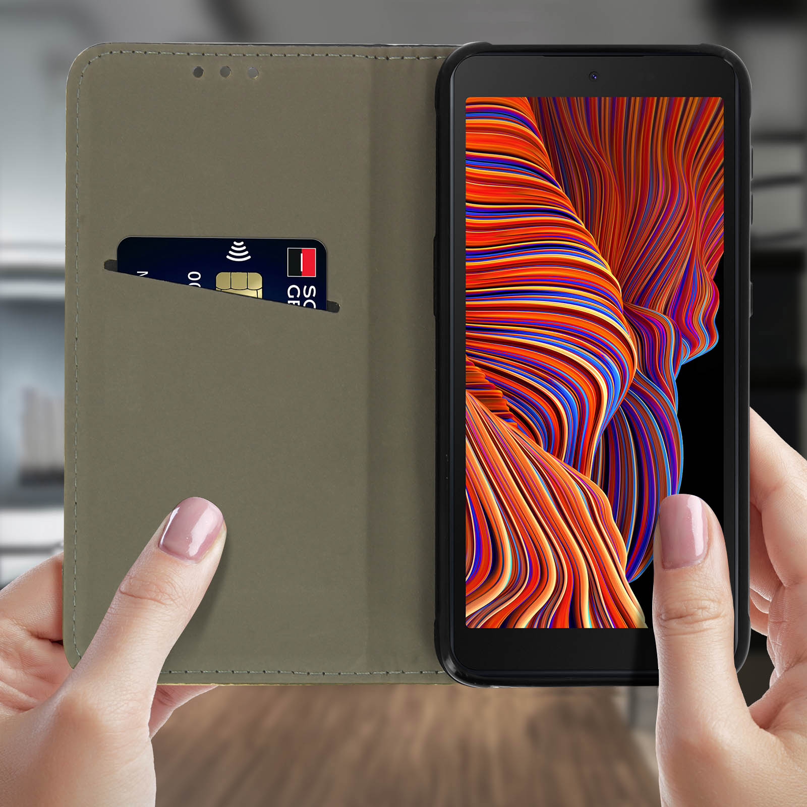 Mani che tengono un telefono in una custodia con una carta. Lo schermo mostra linee colorate. La custodia è verde oliva.