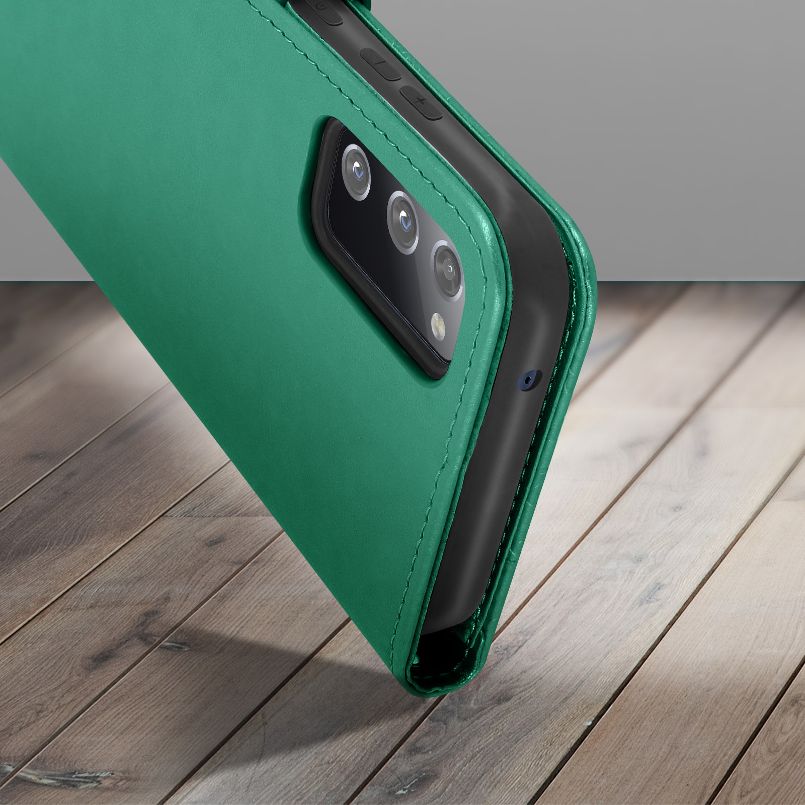 Custodia verde, aperta, mostra telefono con più fotocamere. Su superficie di legno.