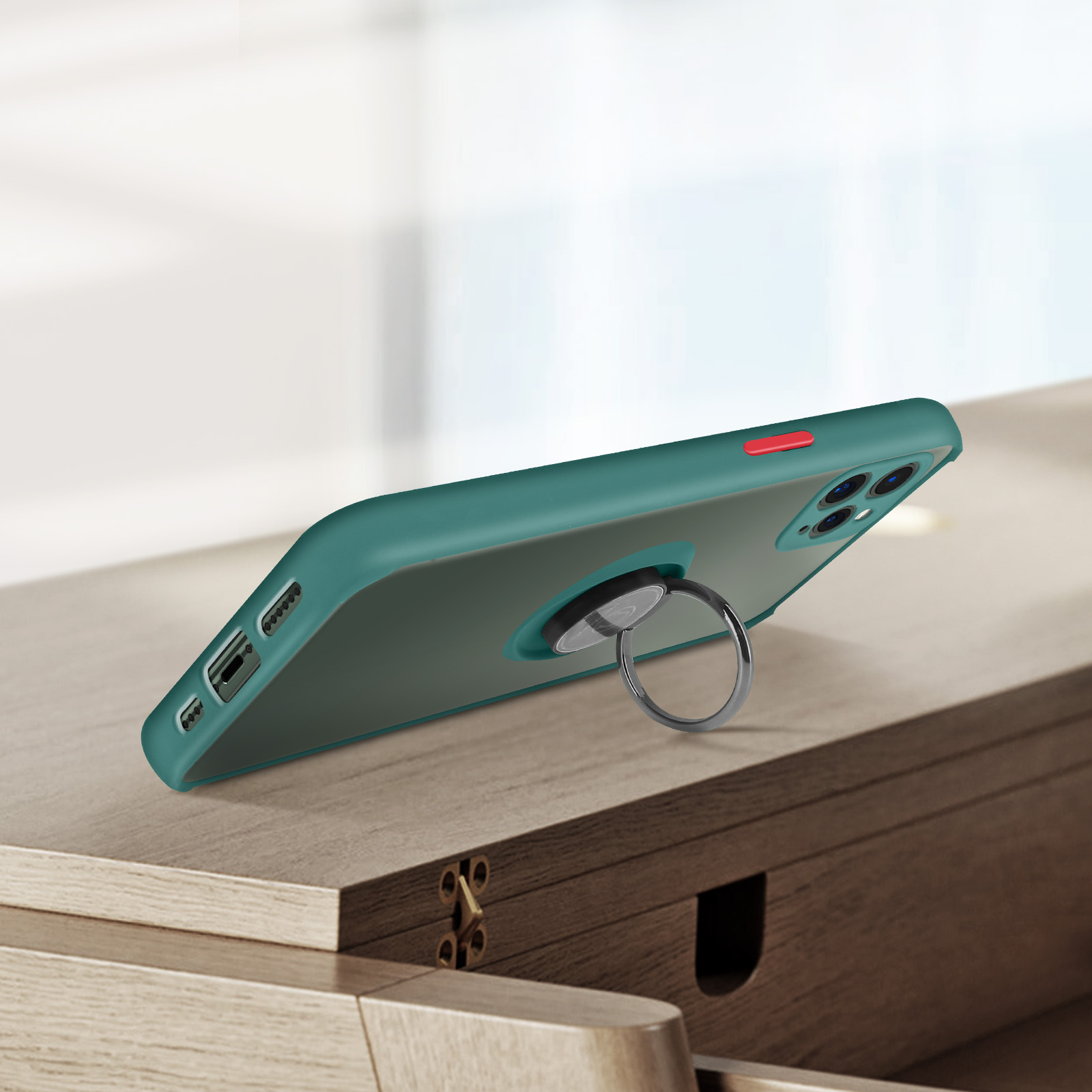 Custodia per telefono verde con supporto ad anello. Il telefono è su una superficie di legno. Sfondo in legno.