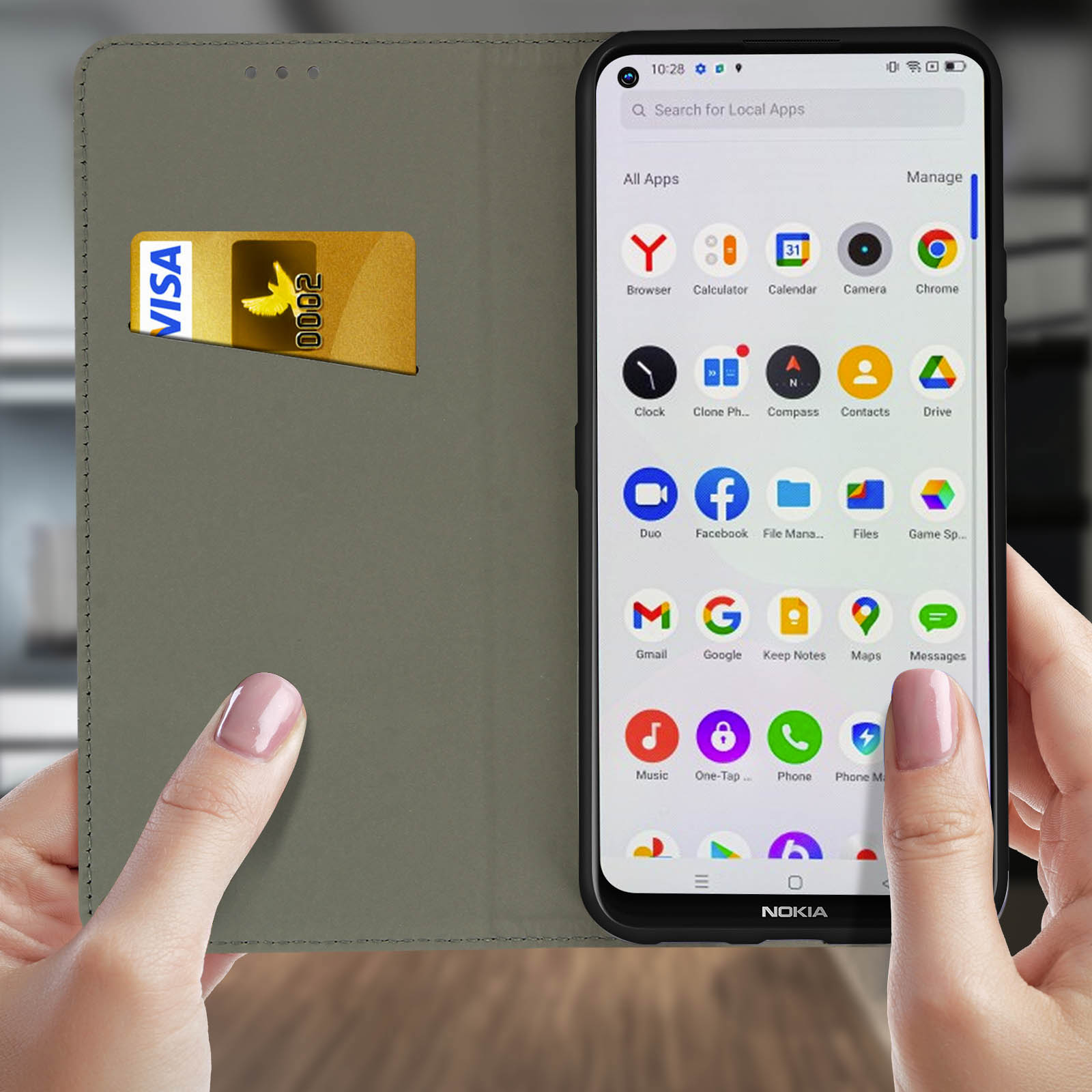 Una persona che tiene una custodia per telefono con un telefono all'interno. Una carta di credito è nella custodia. Sfondo grigio.