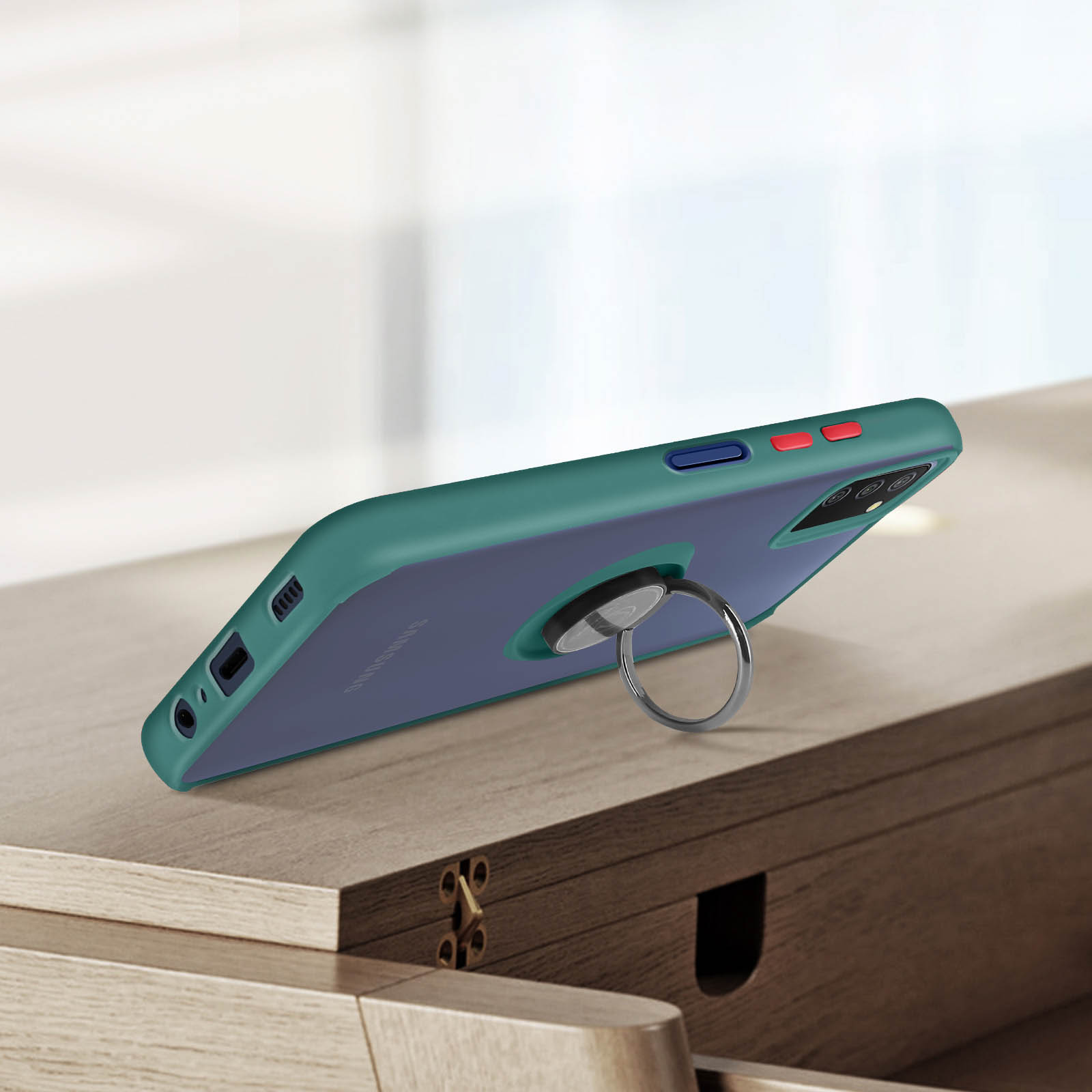 Custodia per telefono verde con un porta anello su un tavolo di legno. Lo sfondo è sfocato.