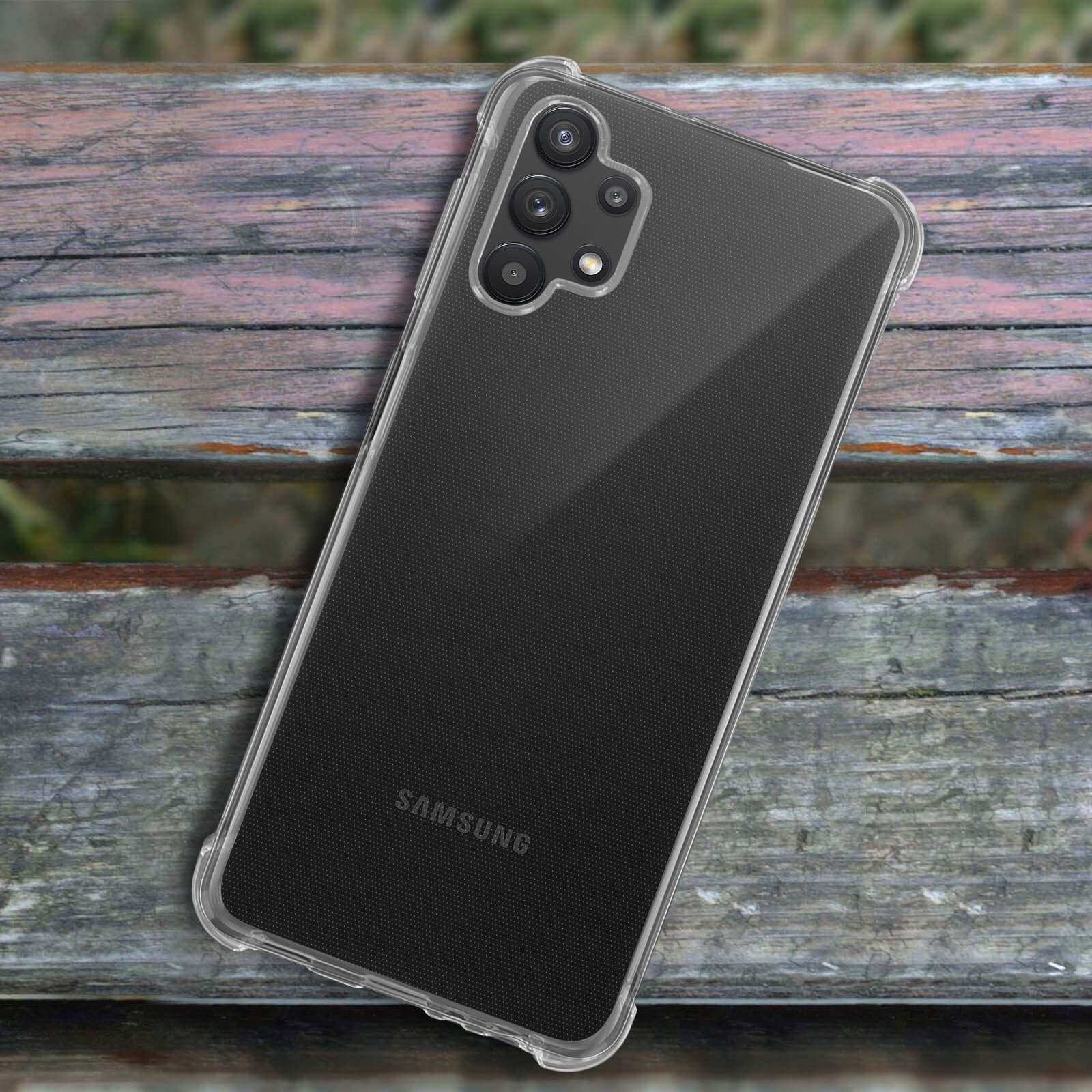 Custodia trasparente per telefono su un tavolo di legno. C'è un telefono nero all'interno. Lo sfondo è sfocato.