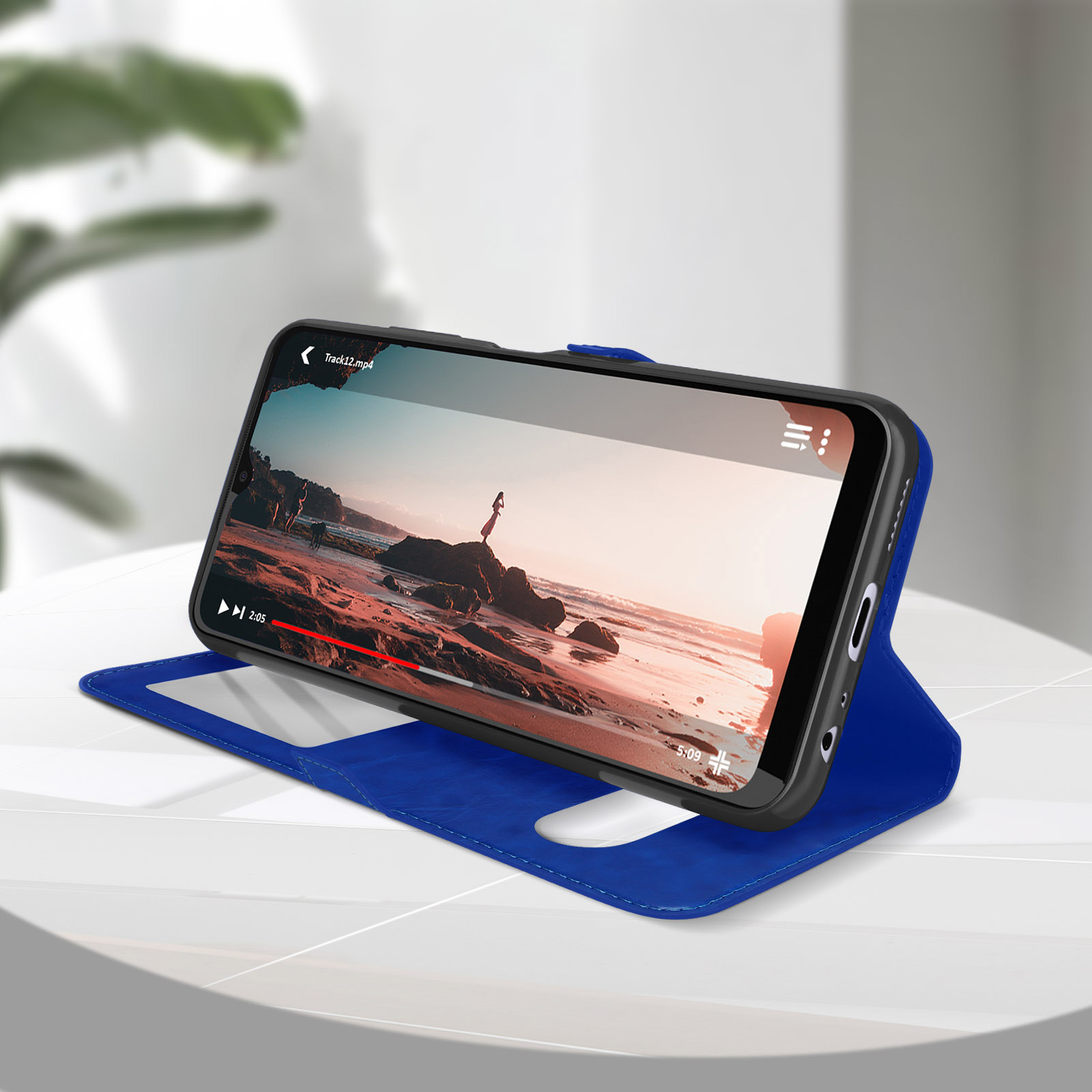 Smartphone dans un étui bleu diffusant une vidéo. Le fond montre une scène de plage.