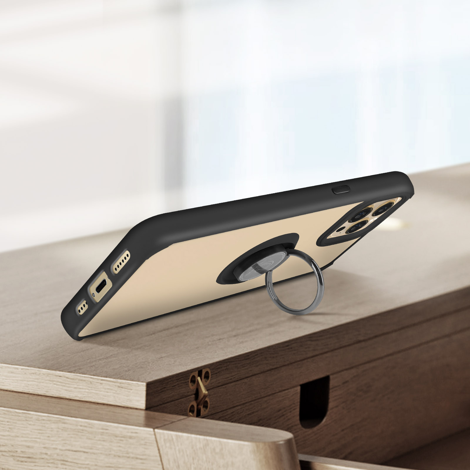 Un telefono in una custodia con un supporto ad anello è angolato su un tavolo di legno.