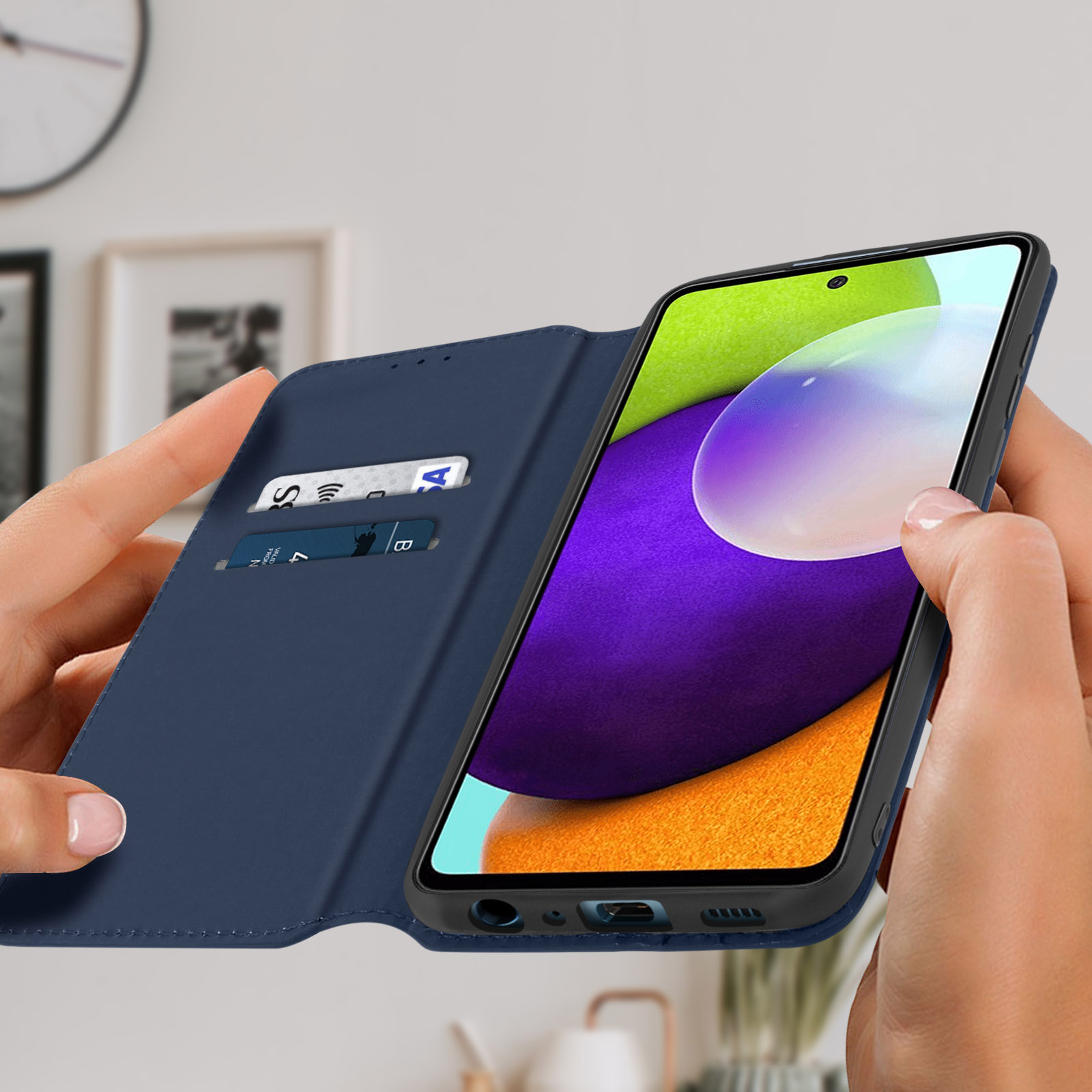 Mani che tengono una custodia blu con un telefono all'interno, rivelando una carta di credito.