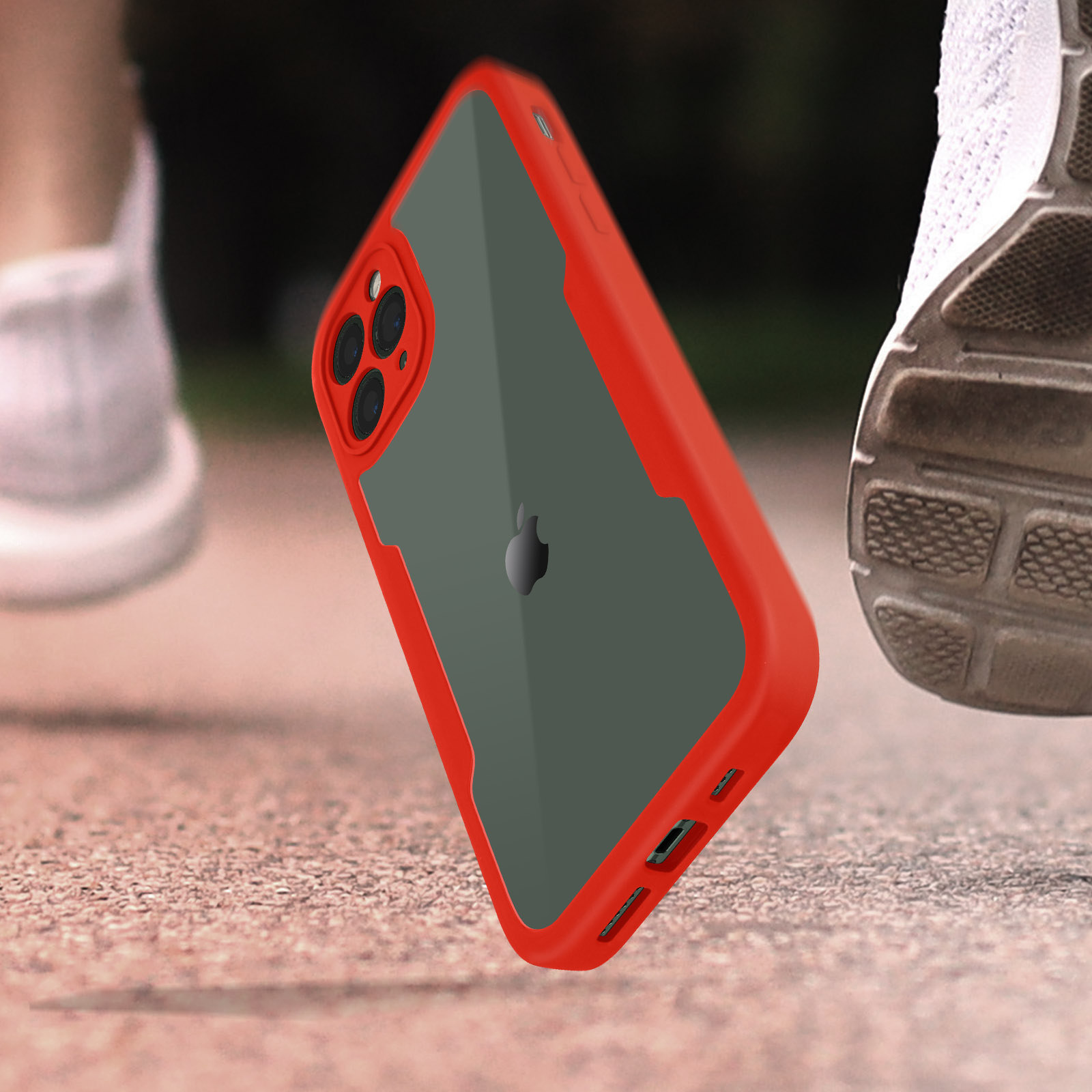 Custodia rossa a mezz'aria, con retro grigio. Il telefono è in movimento. Scarpe da corsa sullo sfondo.