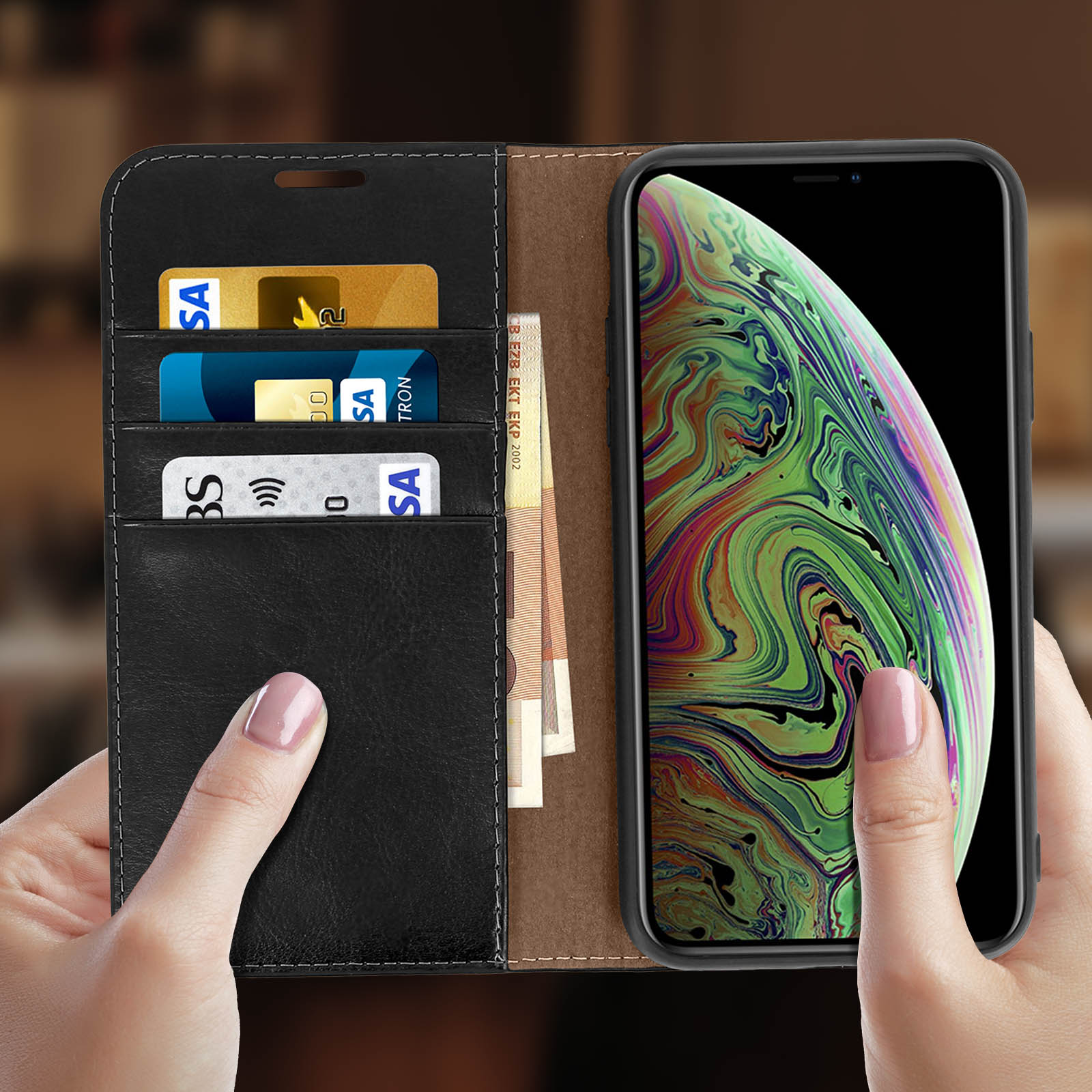 Mano che tiene una custodia per telefono con carte e denaro. Il telefono non è visibile.