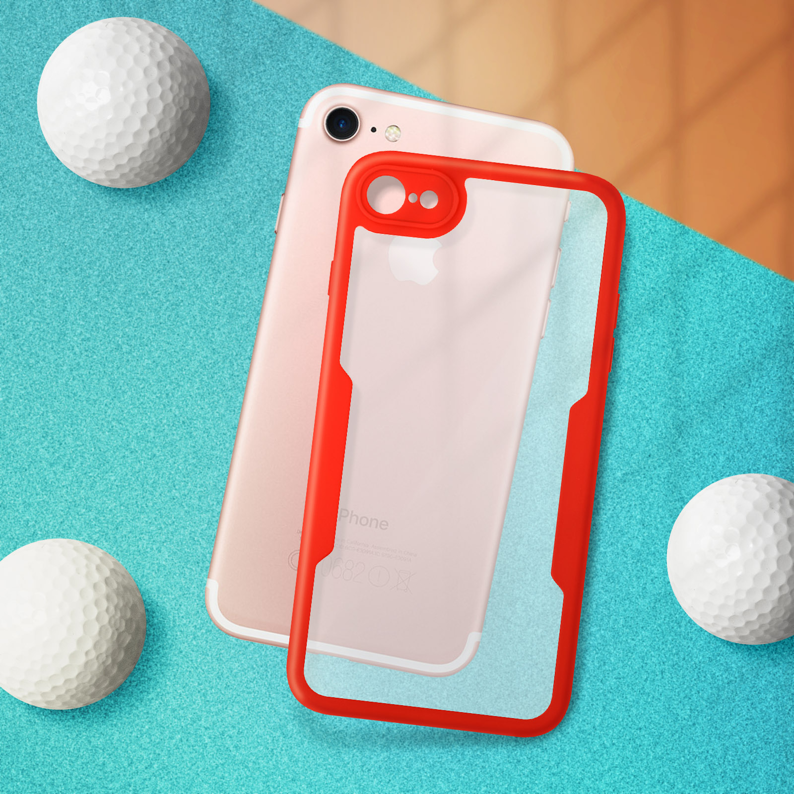 Una custodia rossa sopra un telefono rosa, con palline da golf su una superficie blu. Custodia trasparente.