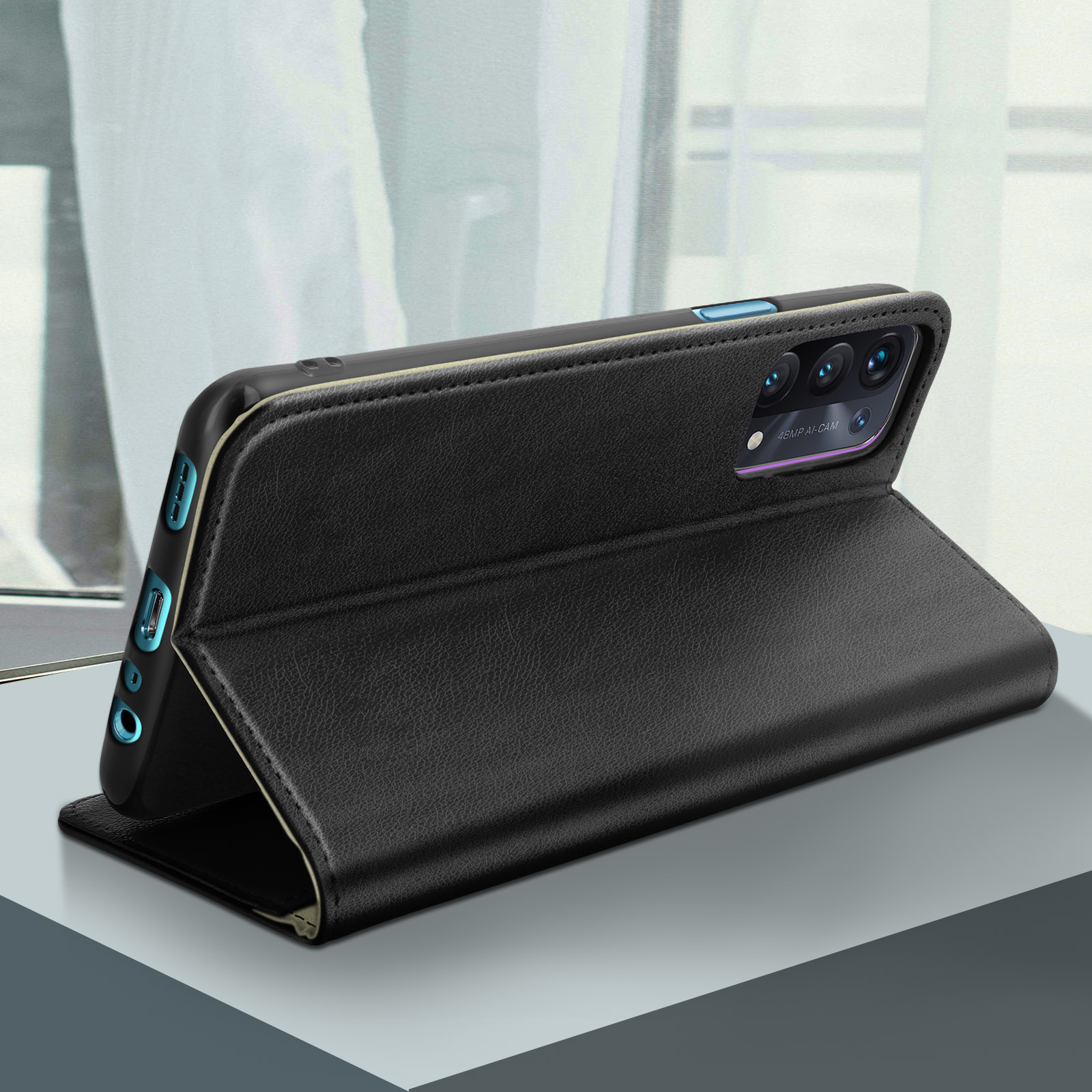 L'étui de téléphone noir est ouvert, soutenant un téléphone. L'étui est sur une surface grise, près d'une fenêtre.