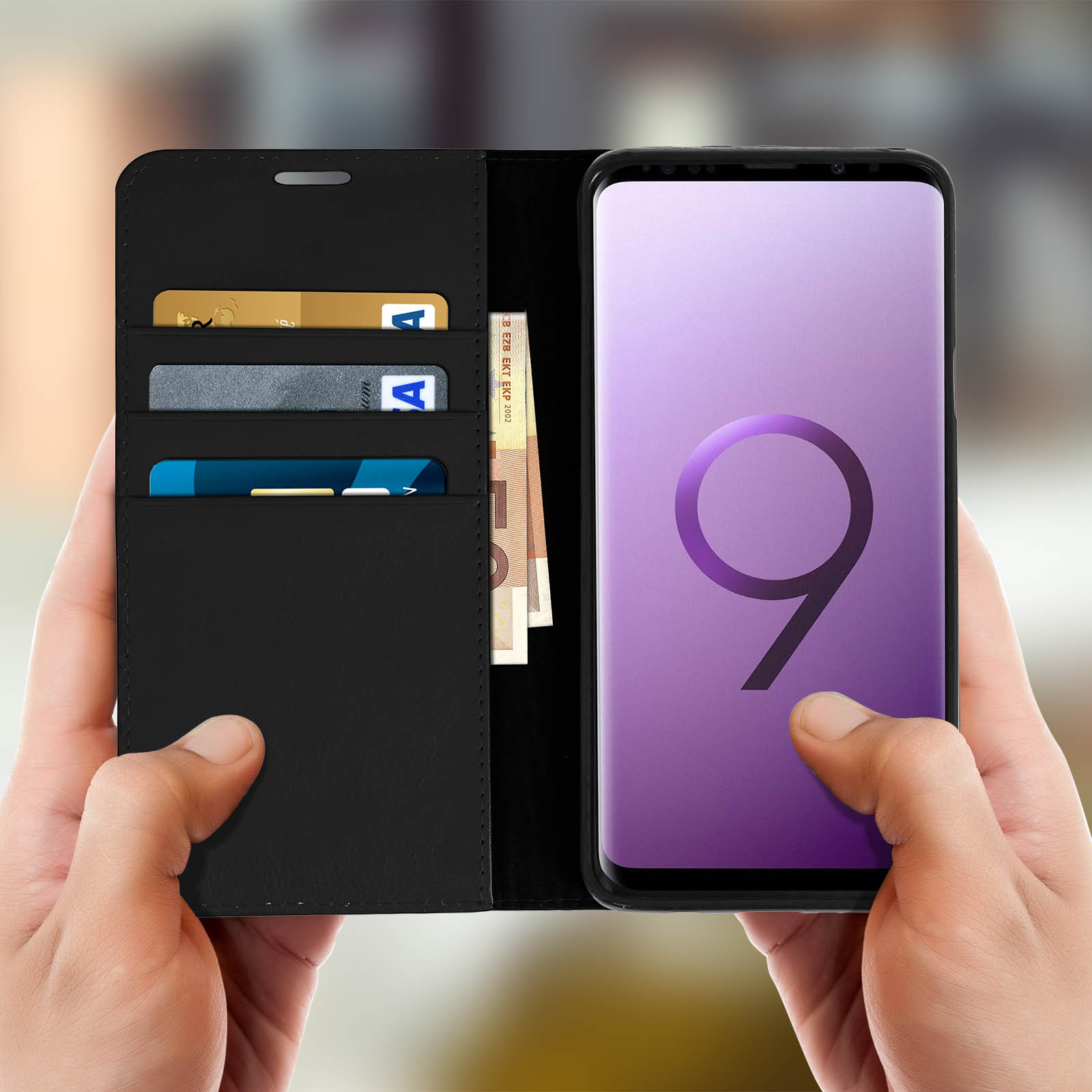 Un telefono in una custodia a portafoglio nera che mostra carte di credito e contanti. Tenuto da due mani.