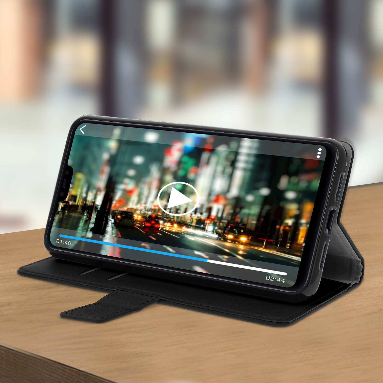 Un telefono mostra un video di una città su una custodia nera. Pulsante di riproduzione visibile.