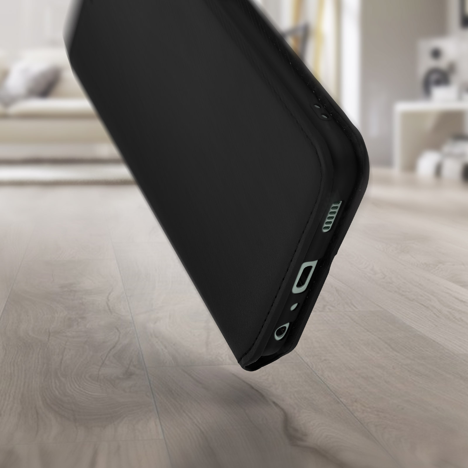 Coque de téléphone noire tombant sur un plancher en bois. Vue latérale.