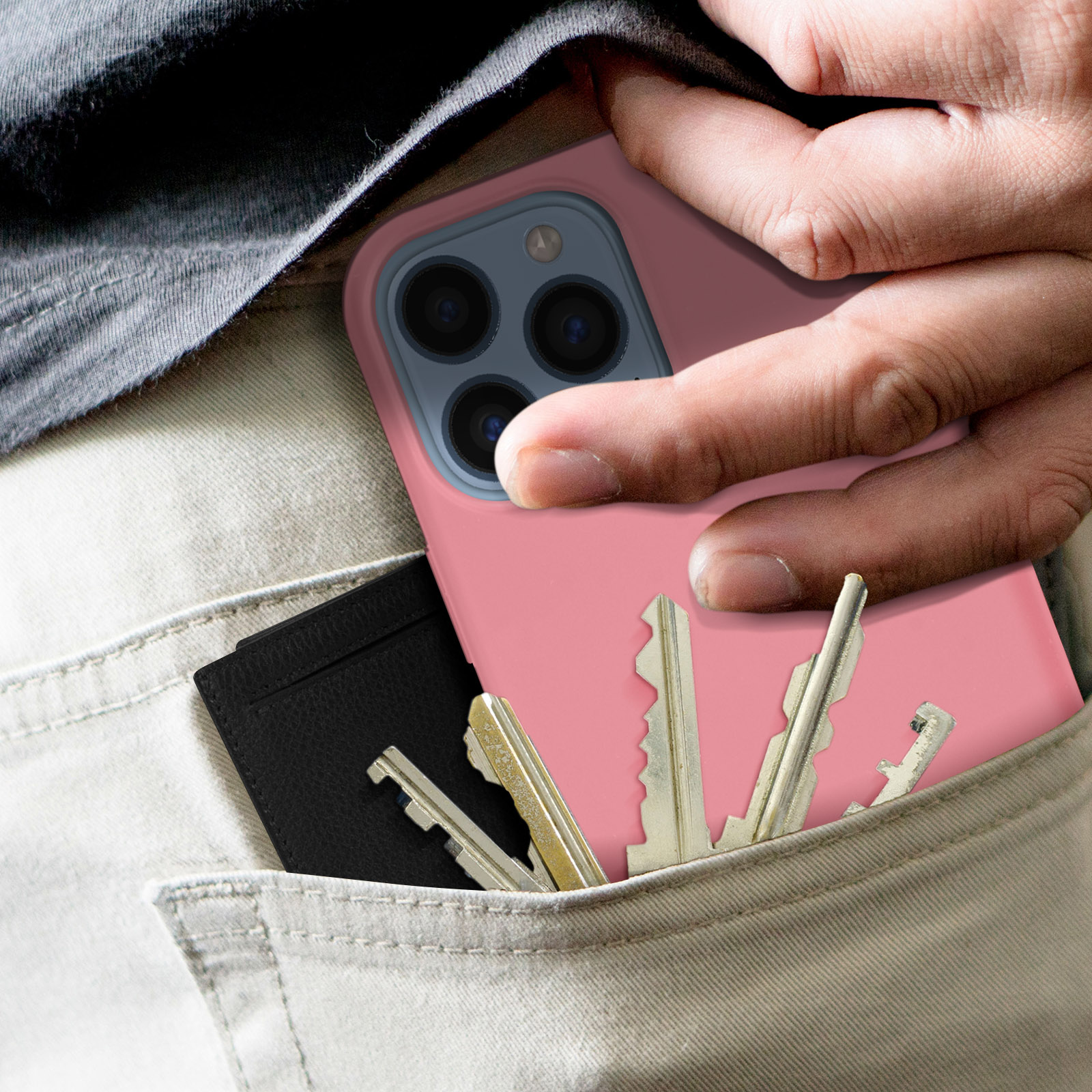 Main dans la poche avec un étui de téléphone contenant téléphone, clés et porte-cartes noir à l'intérieur.