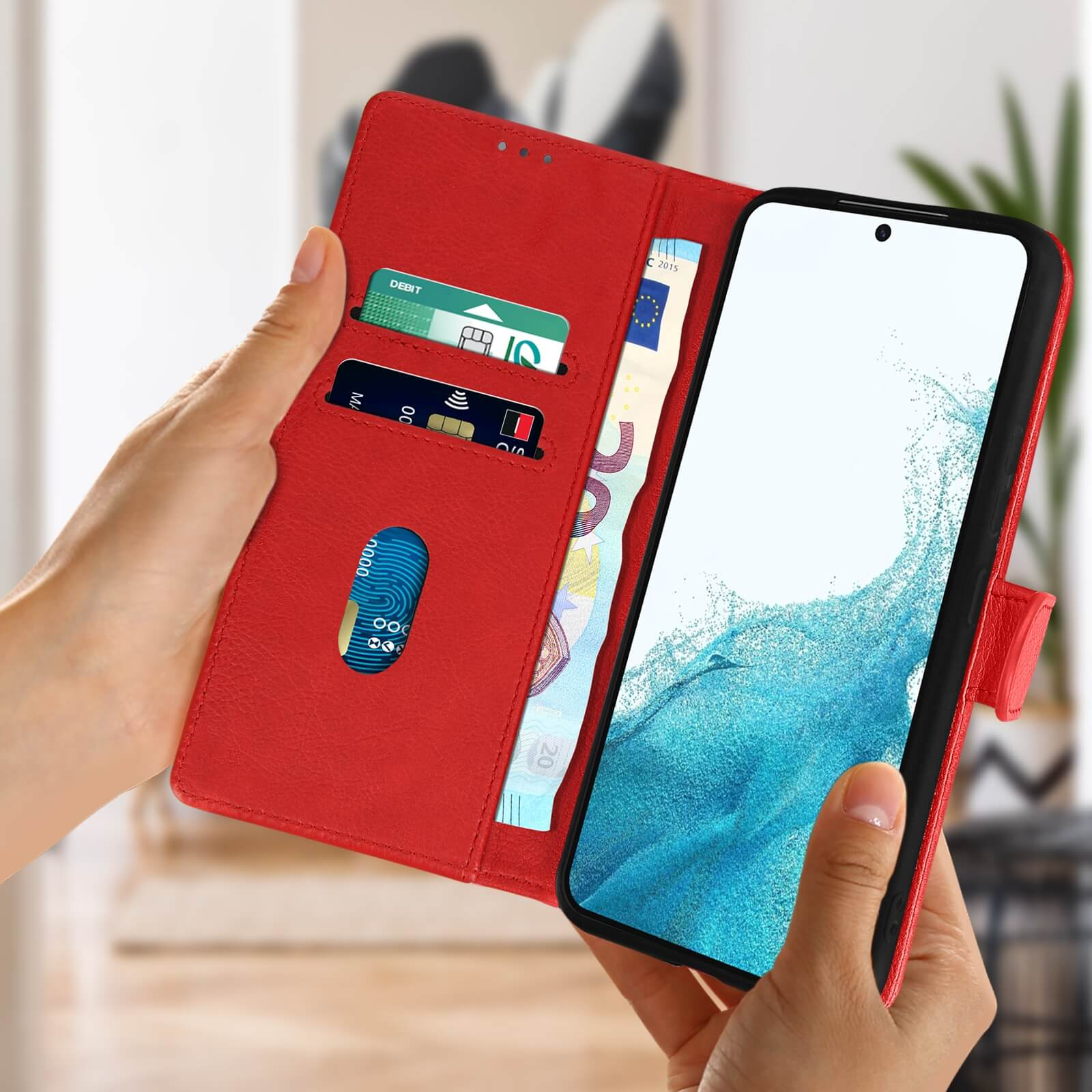 Una mano che tiene una custodia rossa per telefono aperta, mostrando denaro e carte.
