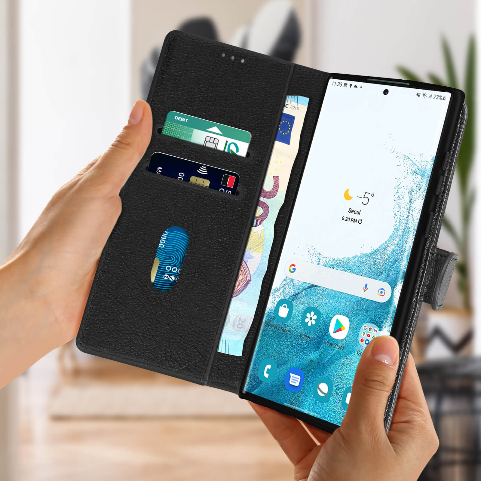 Zwarte telefoonhoes open, met een telefoonscherm en kaarten en geld erin.