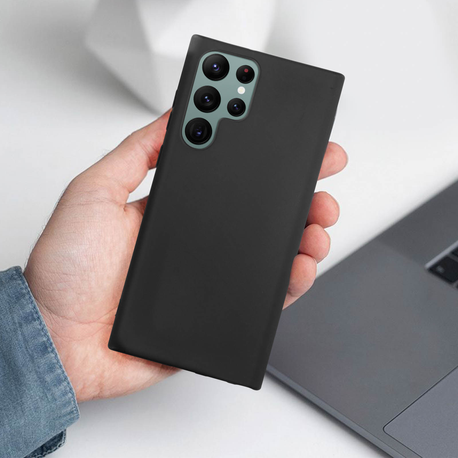 Mano che tiene un telefono nero. Il telefono ha più obiettivi fotografici.