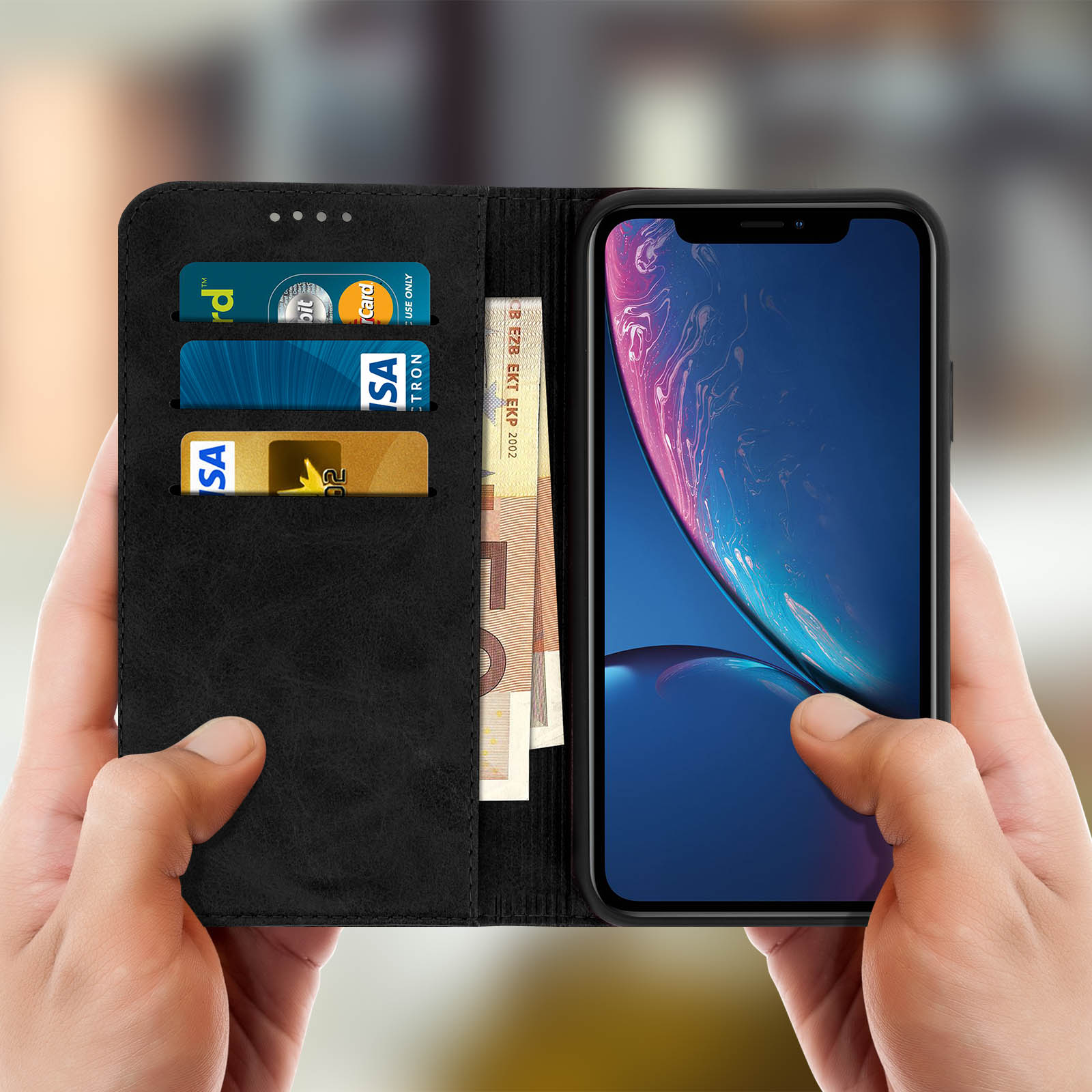 Mani che tengono un telefono con custodia a portafoglio. Carte e denaro visibili.