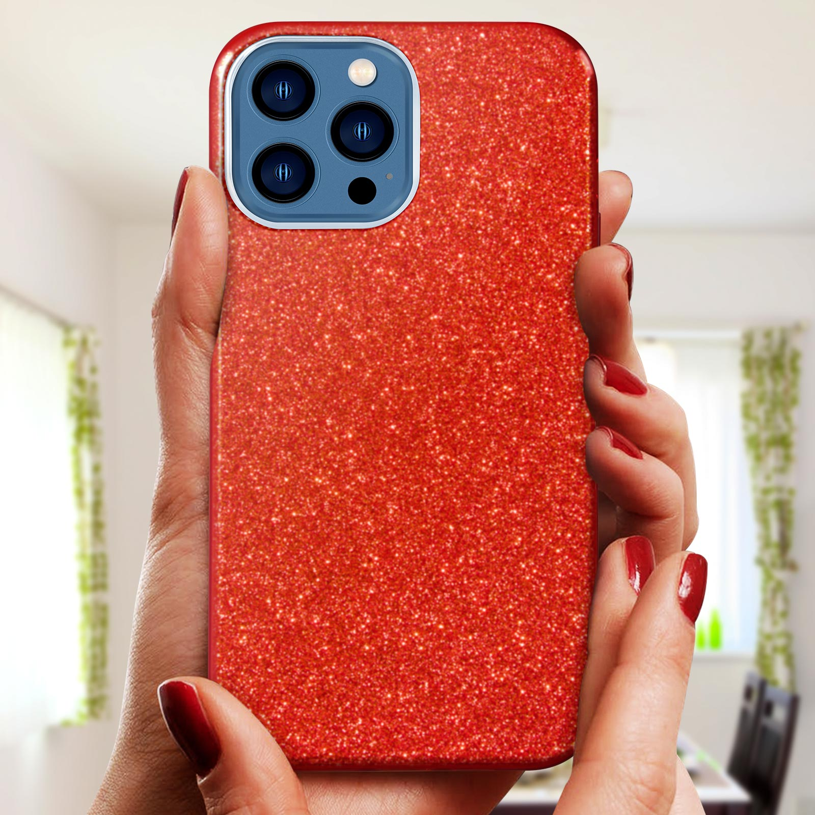 Mani di donna che tengono una custodia rossa glitterata per telefono con protuberanza della fotocamera.
