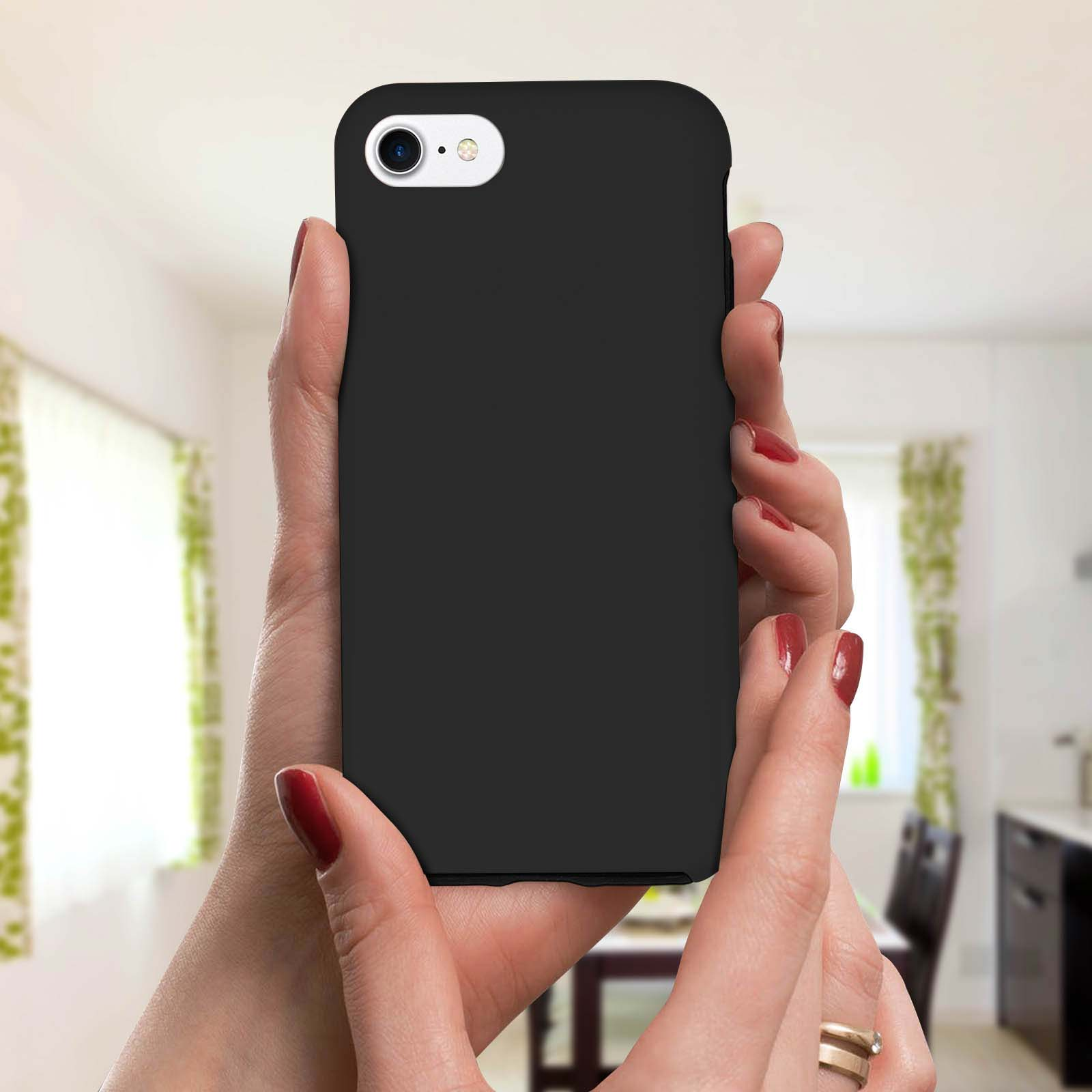 Una persona tiene in mano una custodia nera per telefono con un foro per la fotocamera. Hanno lo smalto rosso.