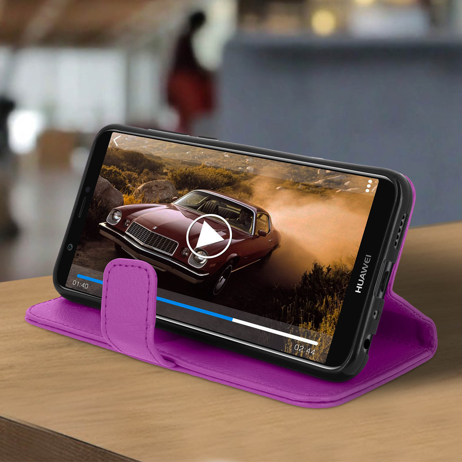 Telefono in una custodia viola che riproduce un video. Lo sfondo è una superficie di legno. Il telefono è aperto.