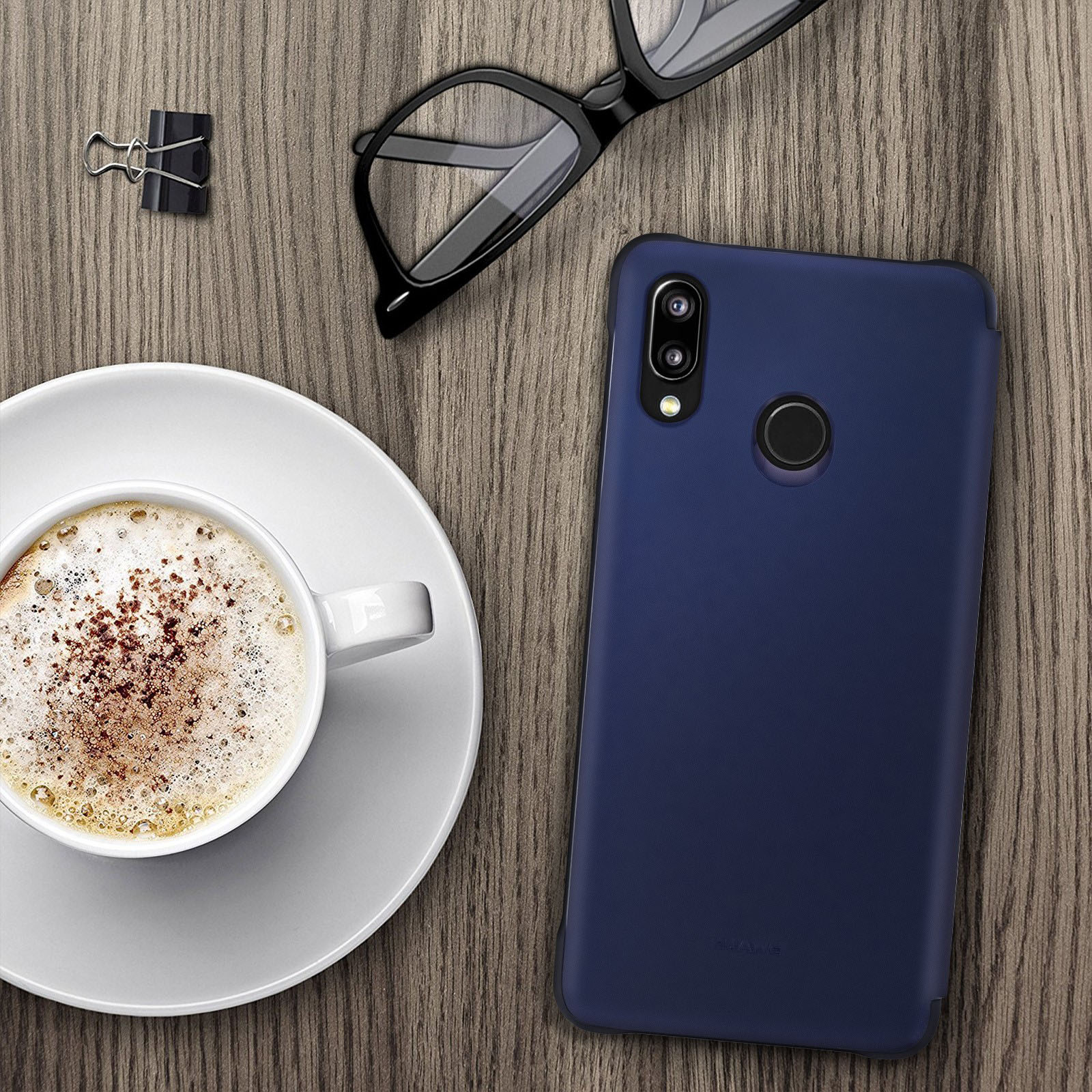 Custodia blu per telefono su un tavolo di legno accanto a una tazza di caffè e occhiali.