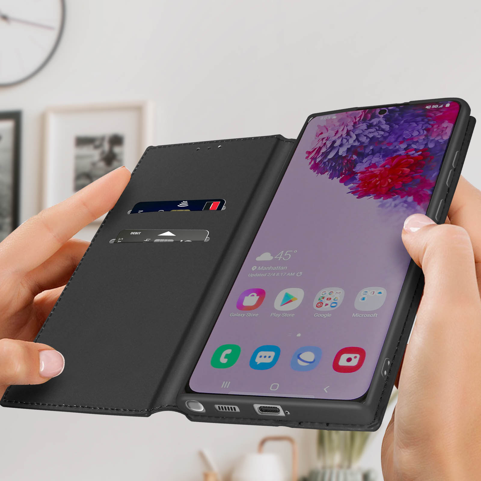 Des mains tiennent un téléphone dans un étui noir, l'écran affiche une application téléphonique.