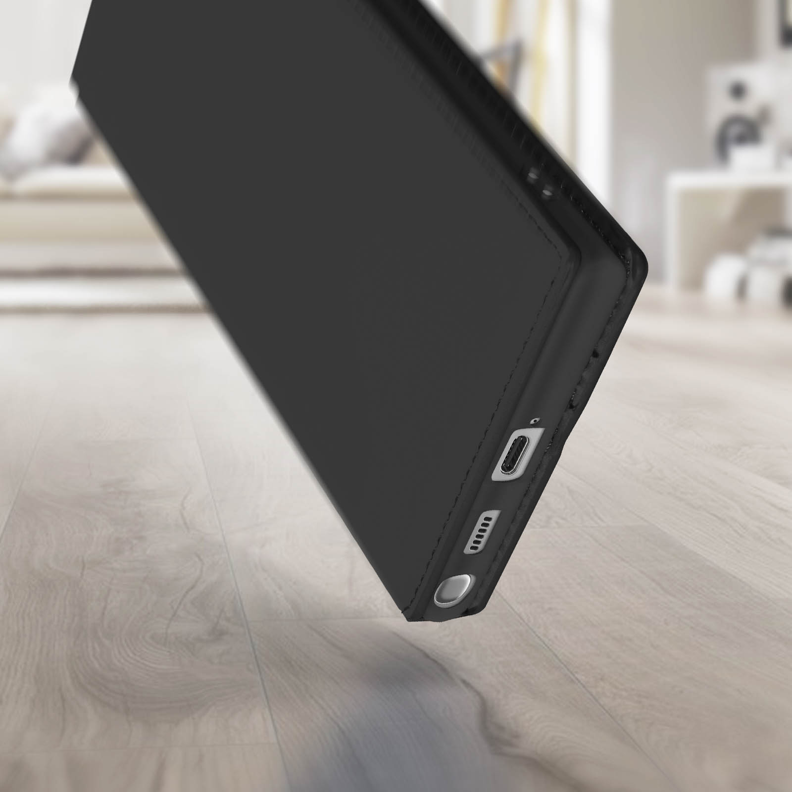 Étui de téléphone noir, incliné, montrant le port de charge et les boutons.