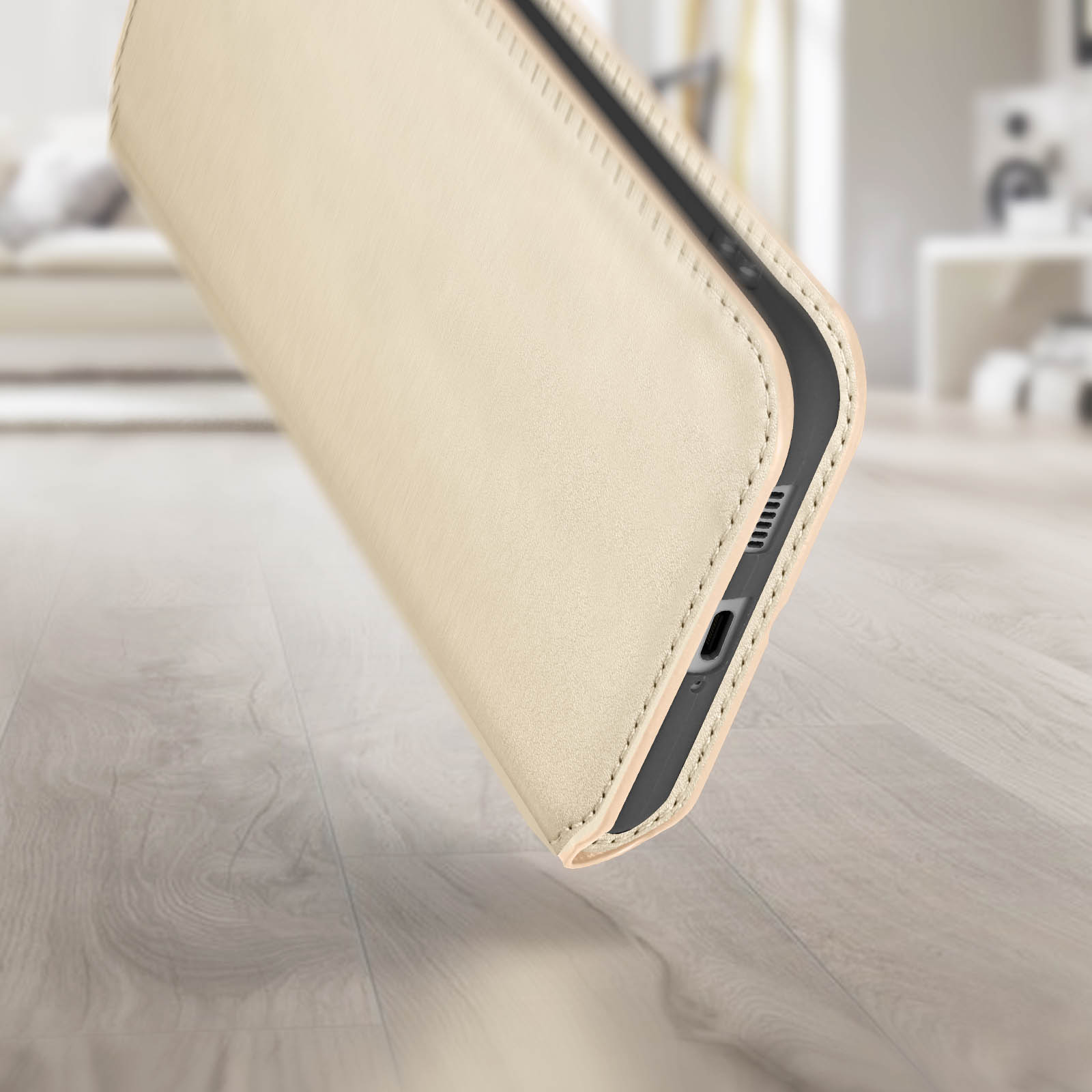 Primo piano di una custodia beige su pavimento in legno. Interno beige visibile, bordo e porta visibili.