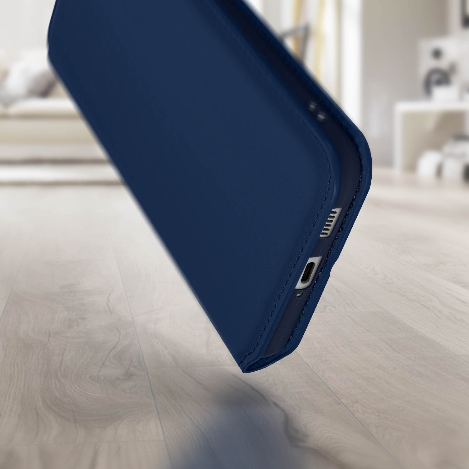 Een blauwe telefoonhoes, schuin om de zijkant met de oplaadpoort en knoppen te laten zien.
